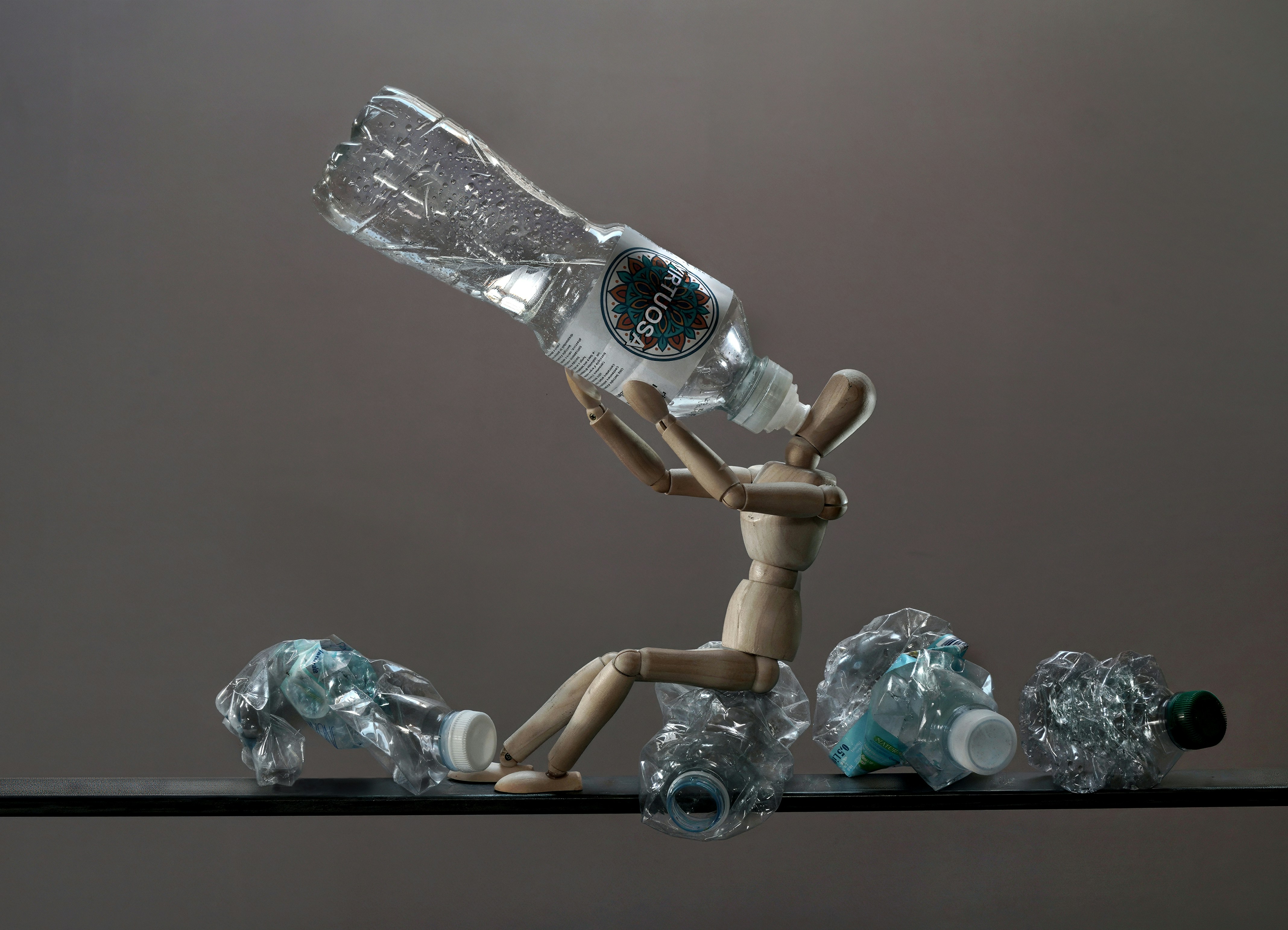 Wooden mannequin with crushed plastic bottles