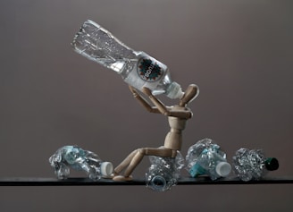 Wooden mannequin with crushed plastic bottles