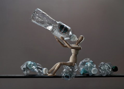 Wooden mannequin with crushed plastic bottles