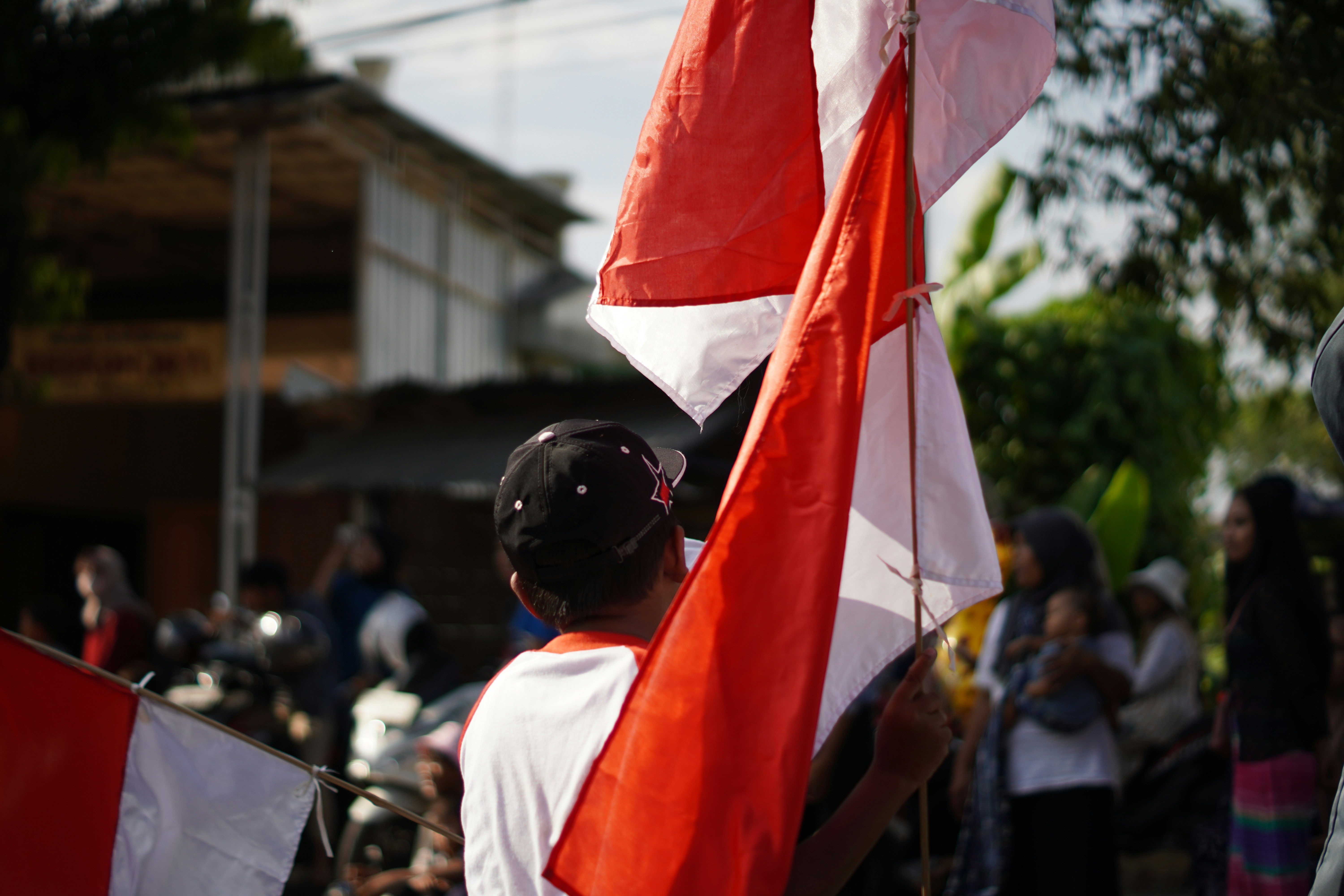 A person holding a red and white flag.