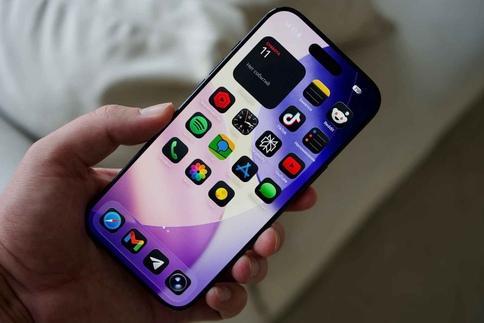 Hand holding a smartphone with colorful app icons