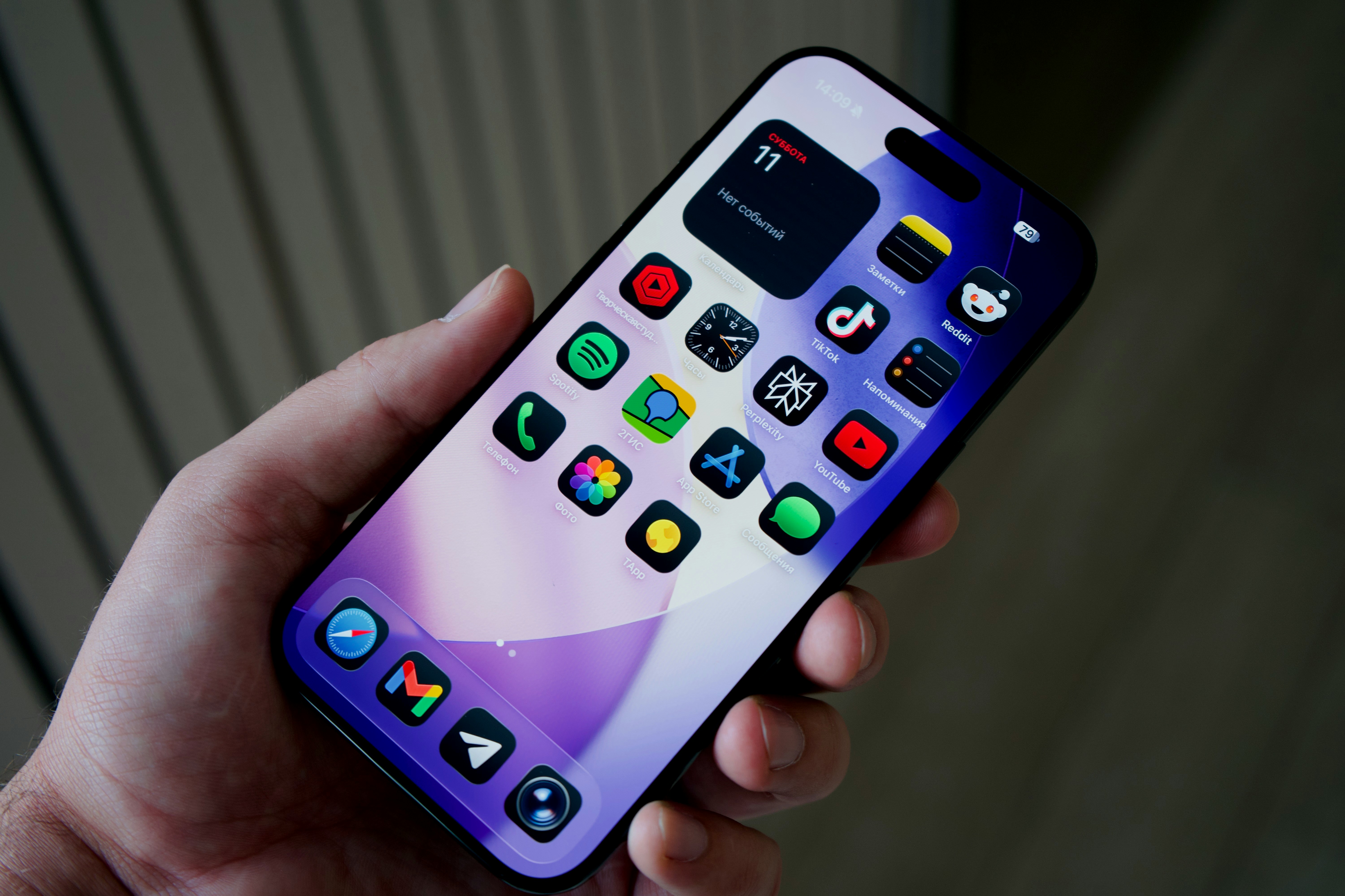 Hand holding smartphone with colorful app icons