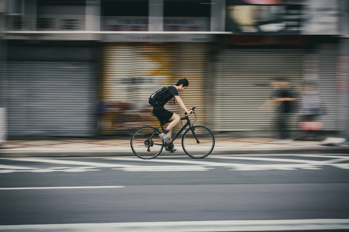 Man riding bicycle on city street with motion blur