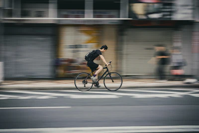 Man riding bicycle on city street with motion blur