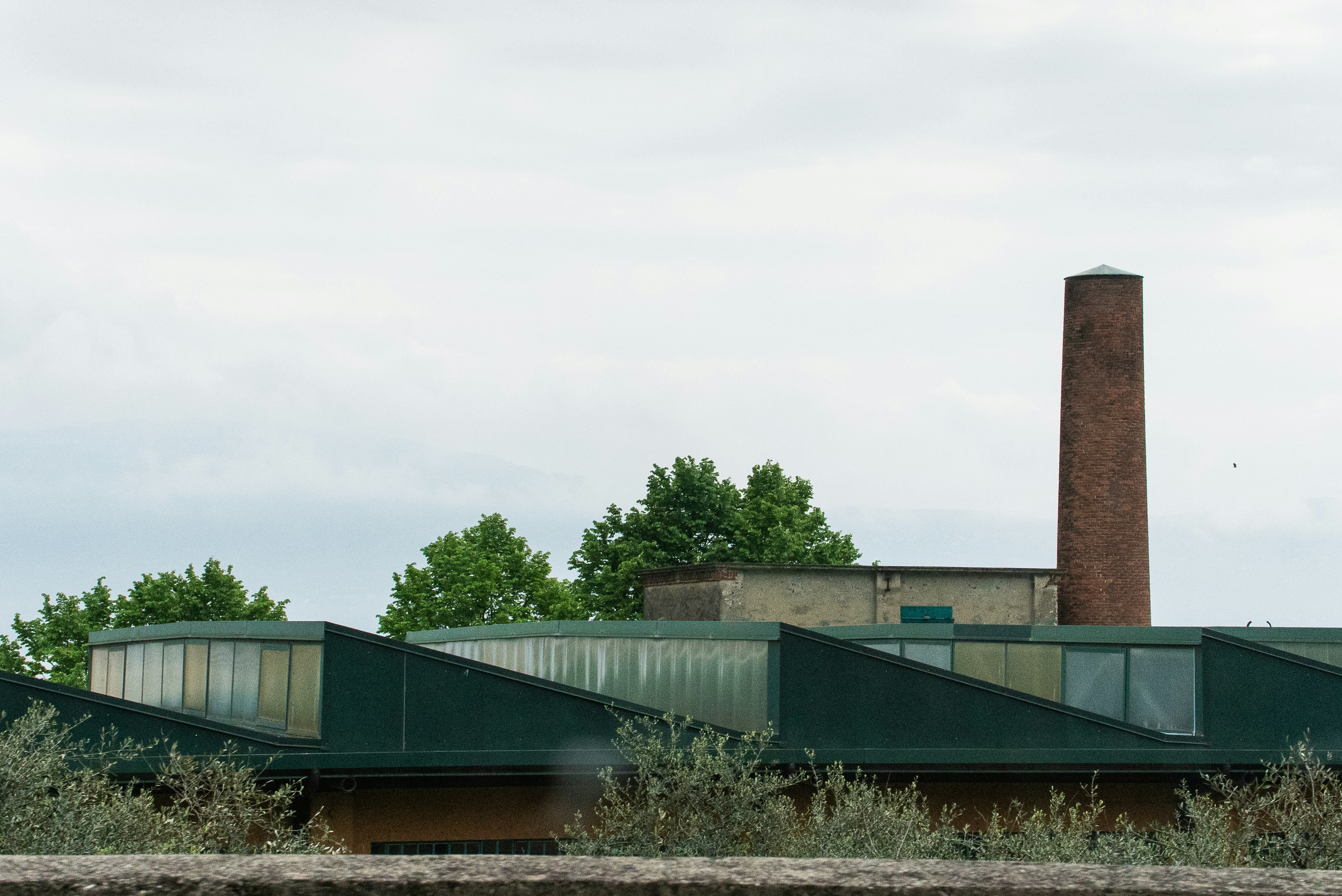Industrial building with a tall brick chimney.