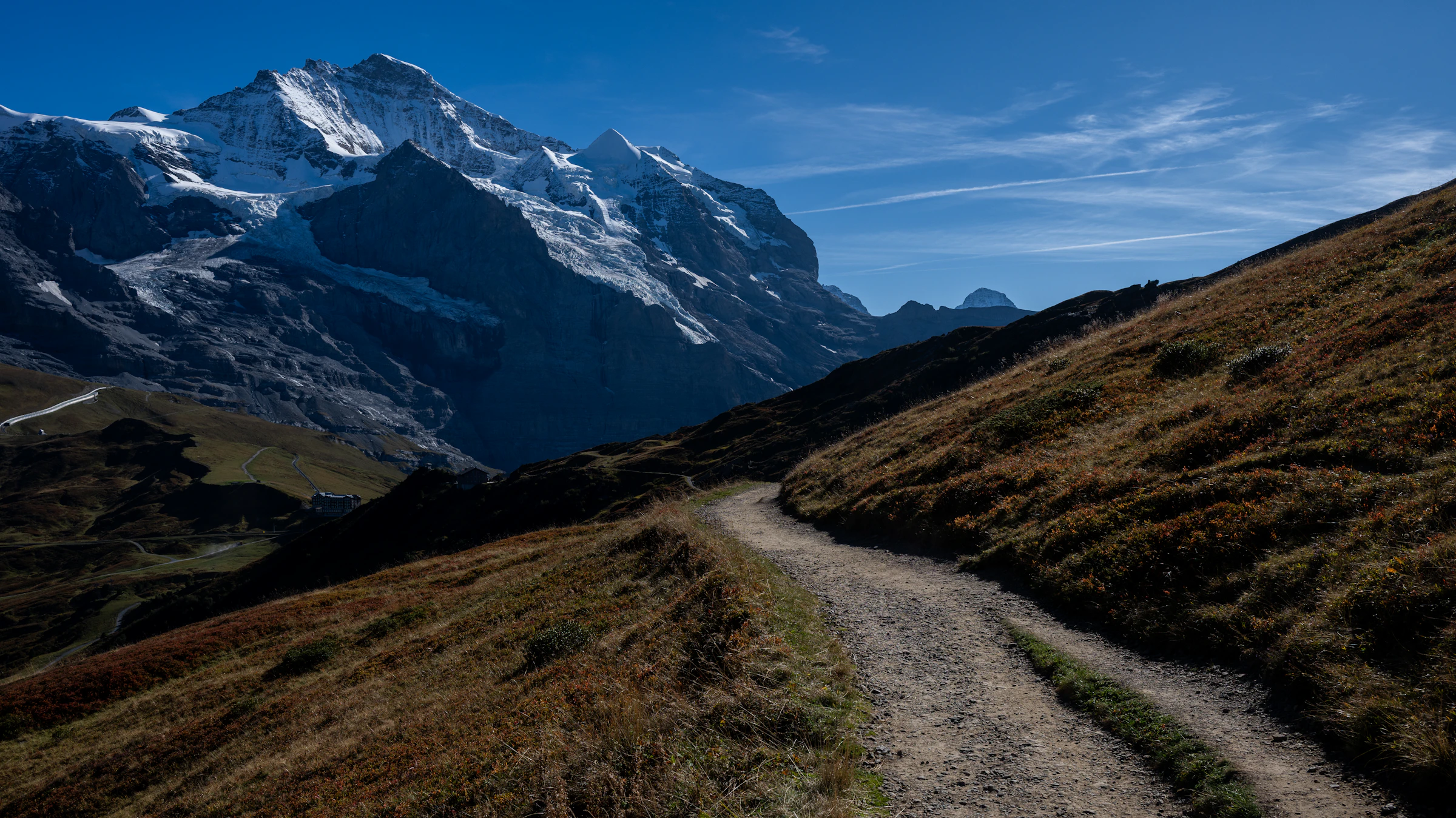 Alpine trail leading towards snow-capped Swiss mountain peaks