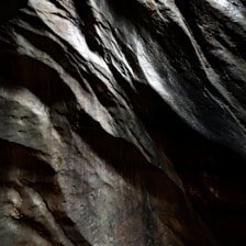 Textured rock surface with dramatic light and shadow