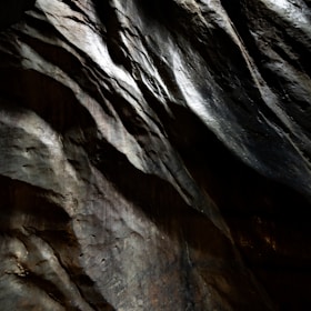 Textured rock surface with dramatic light and shadow