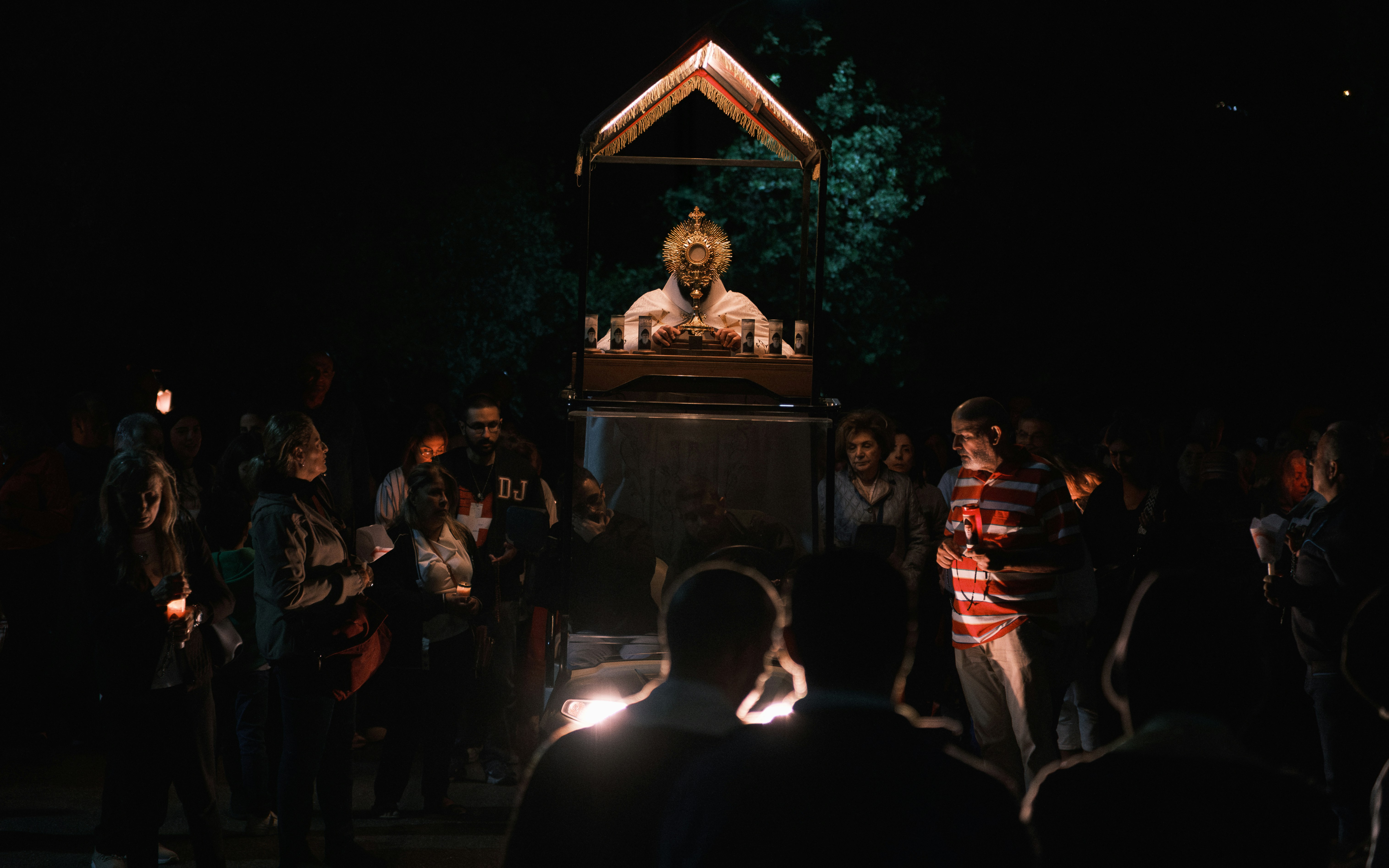 People gather around a ritualistic altar at night.