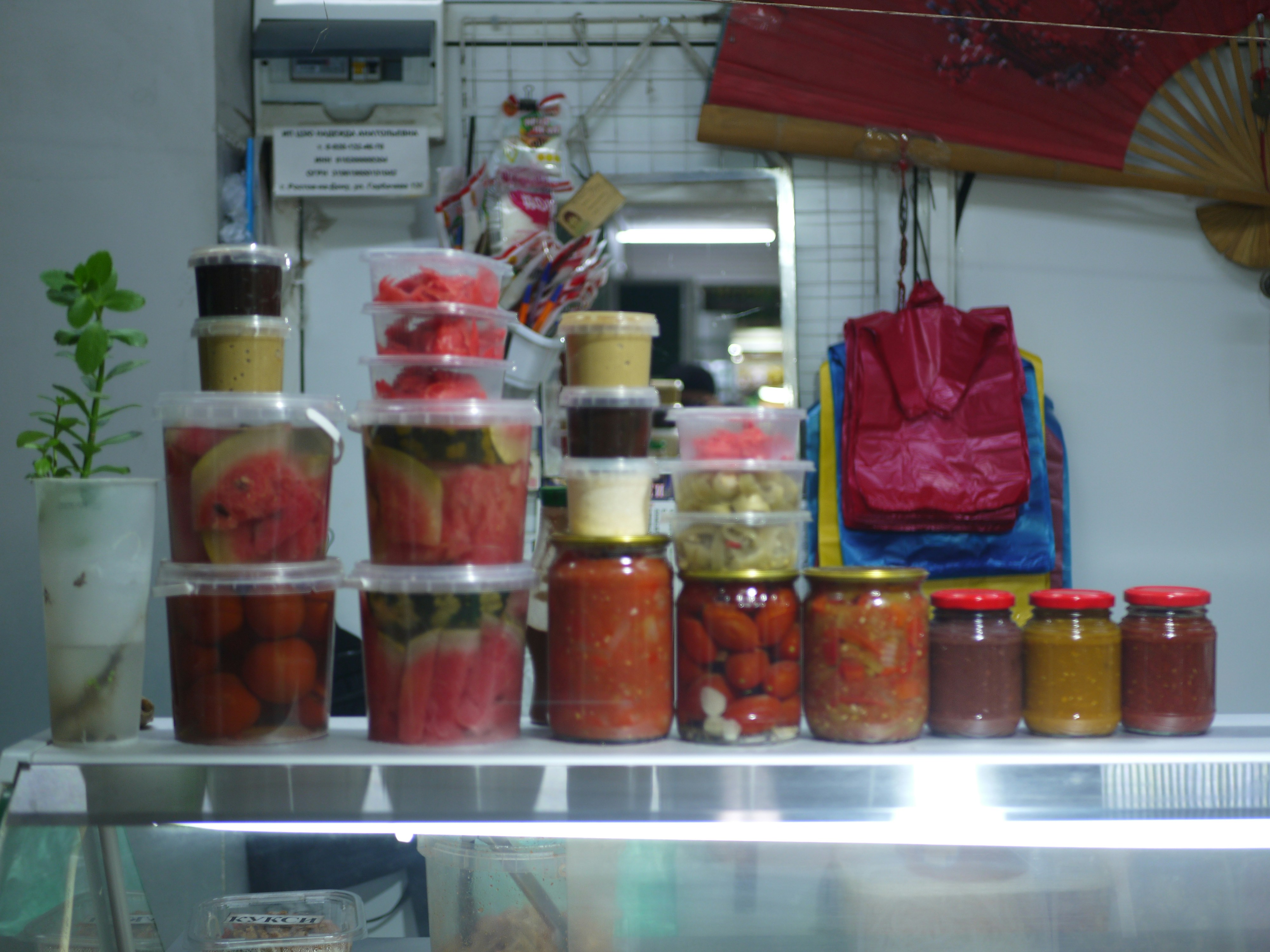 Jars and containers of preserved food on a shelf.