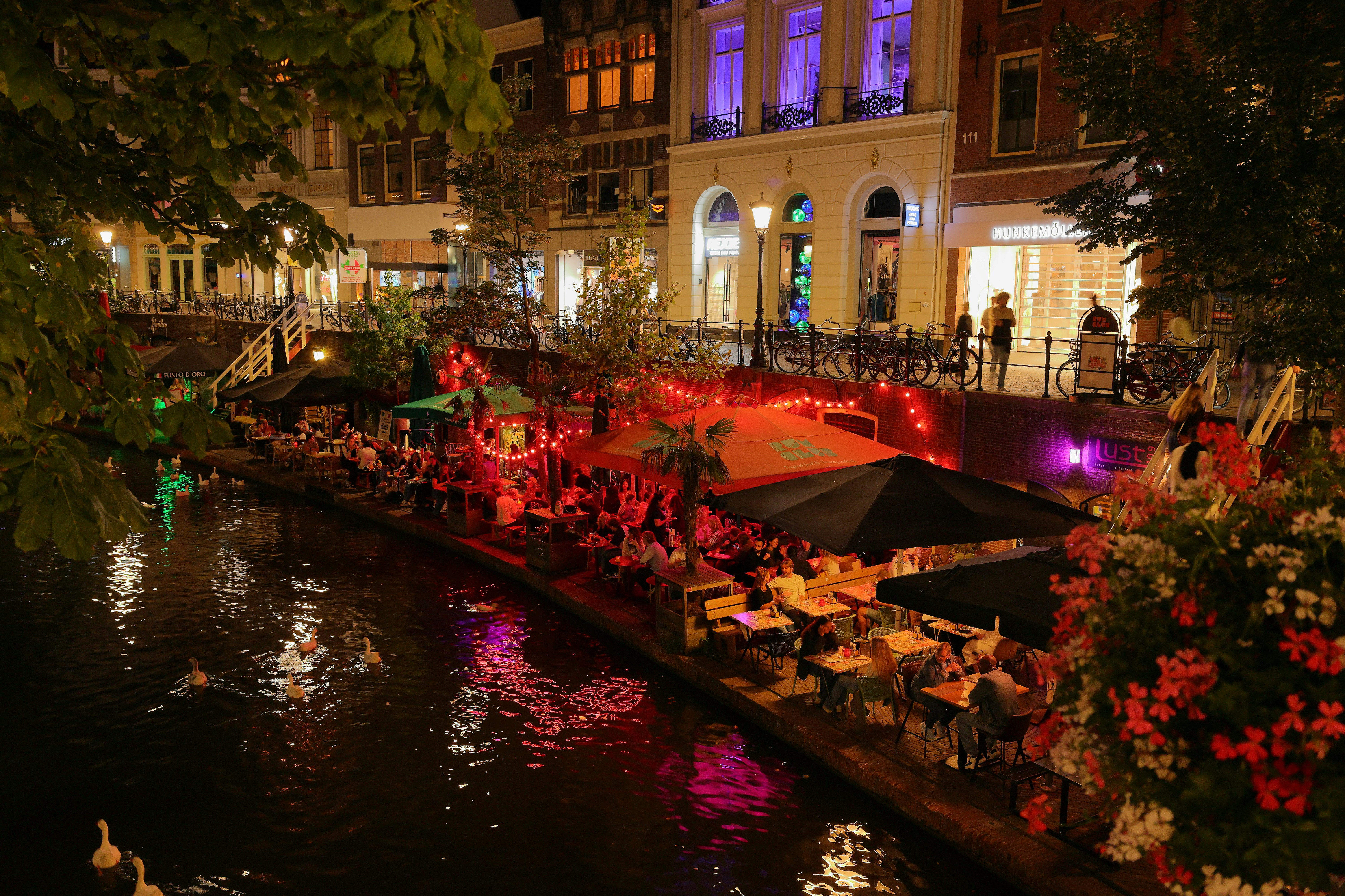 City canal with outdoor cafes at night.