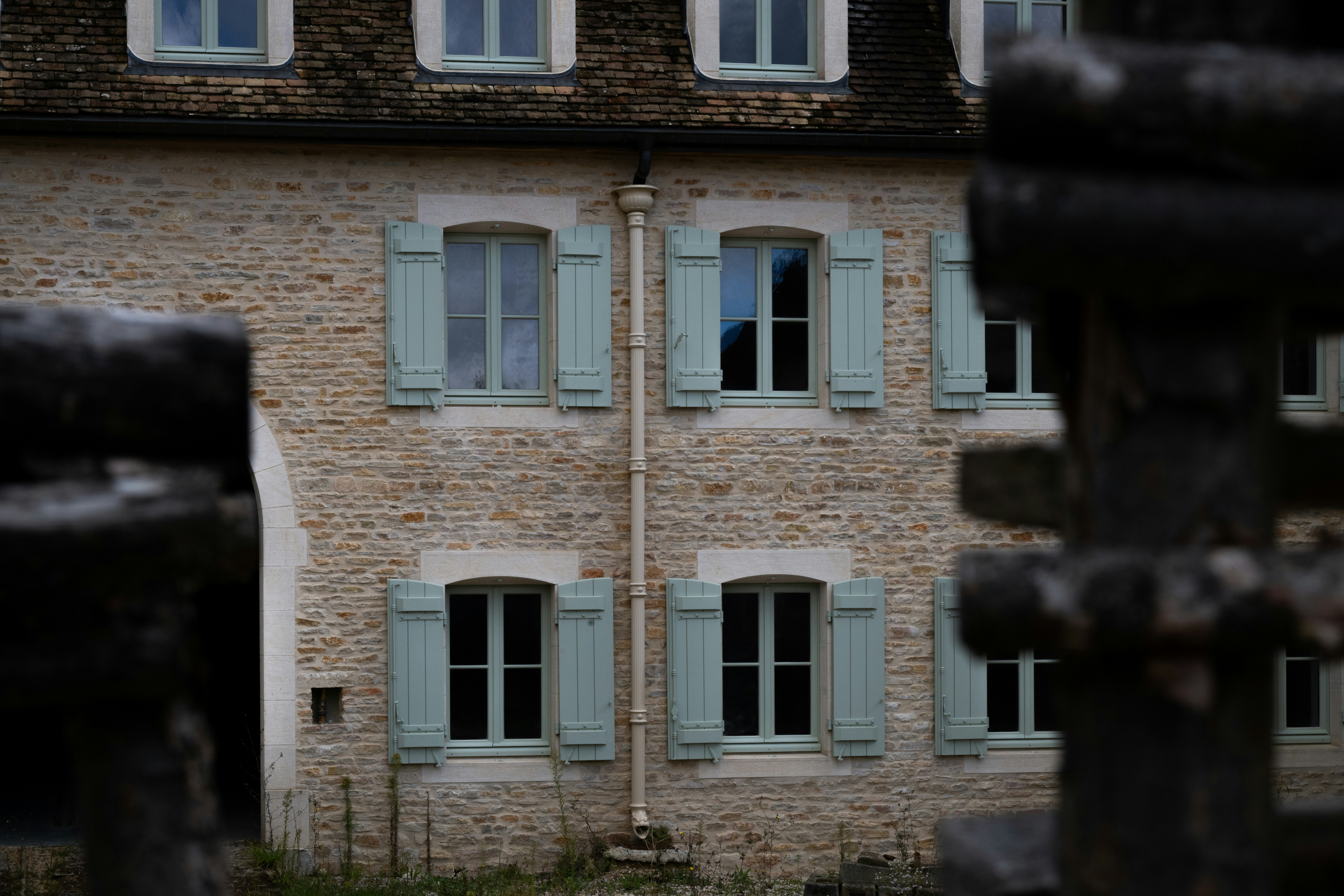 Stone building with light blue shutters on windows.