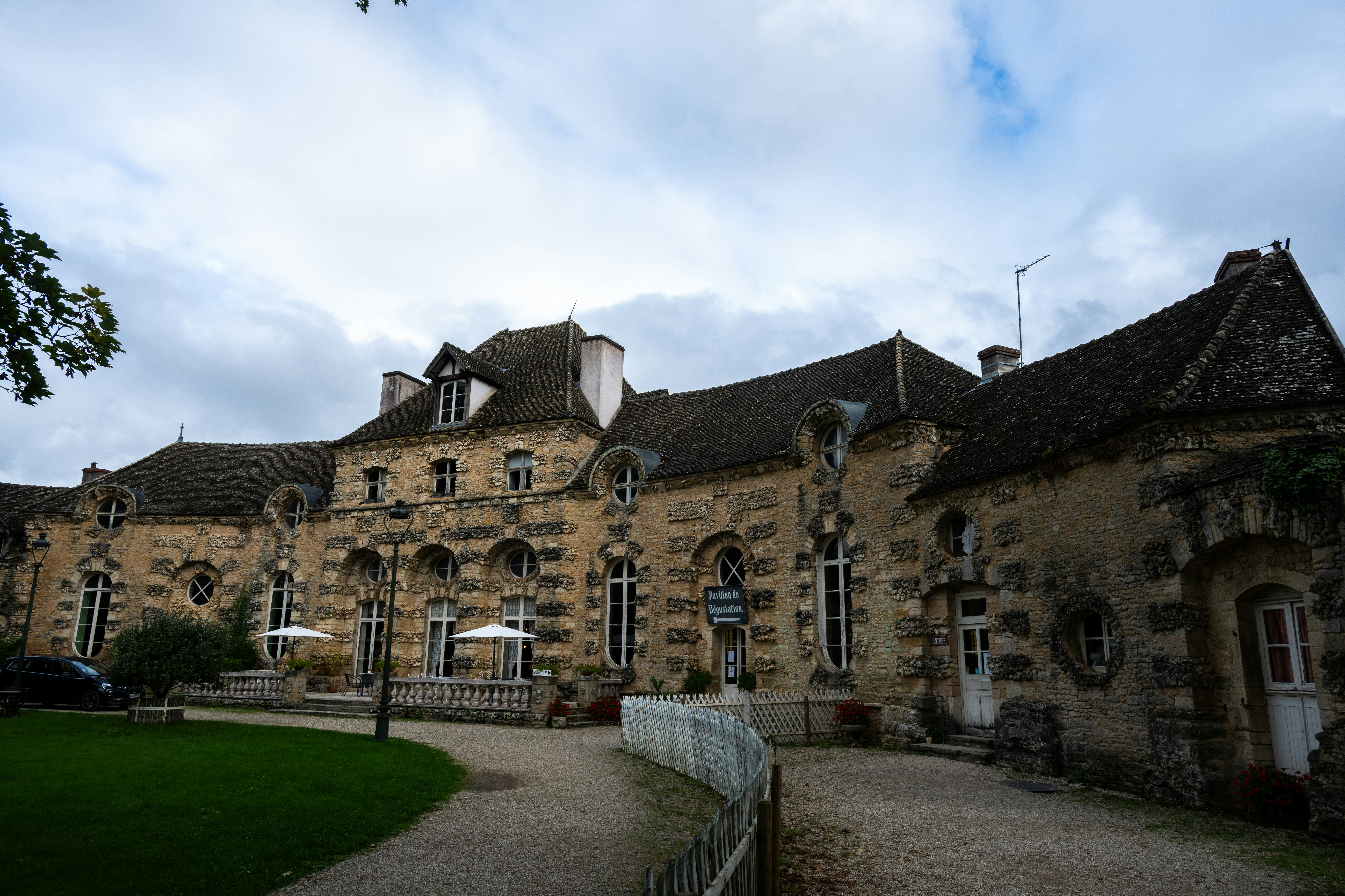 Large stone building with many windows under cloudy sky.