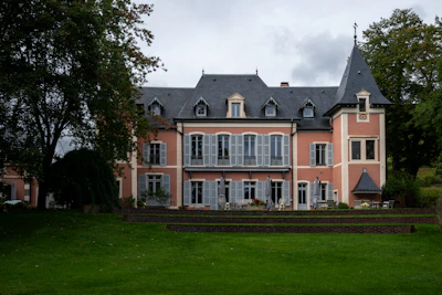 A large pink manor house with a tower.