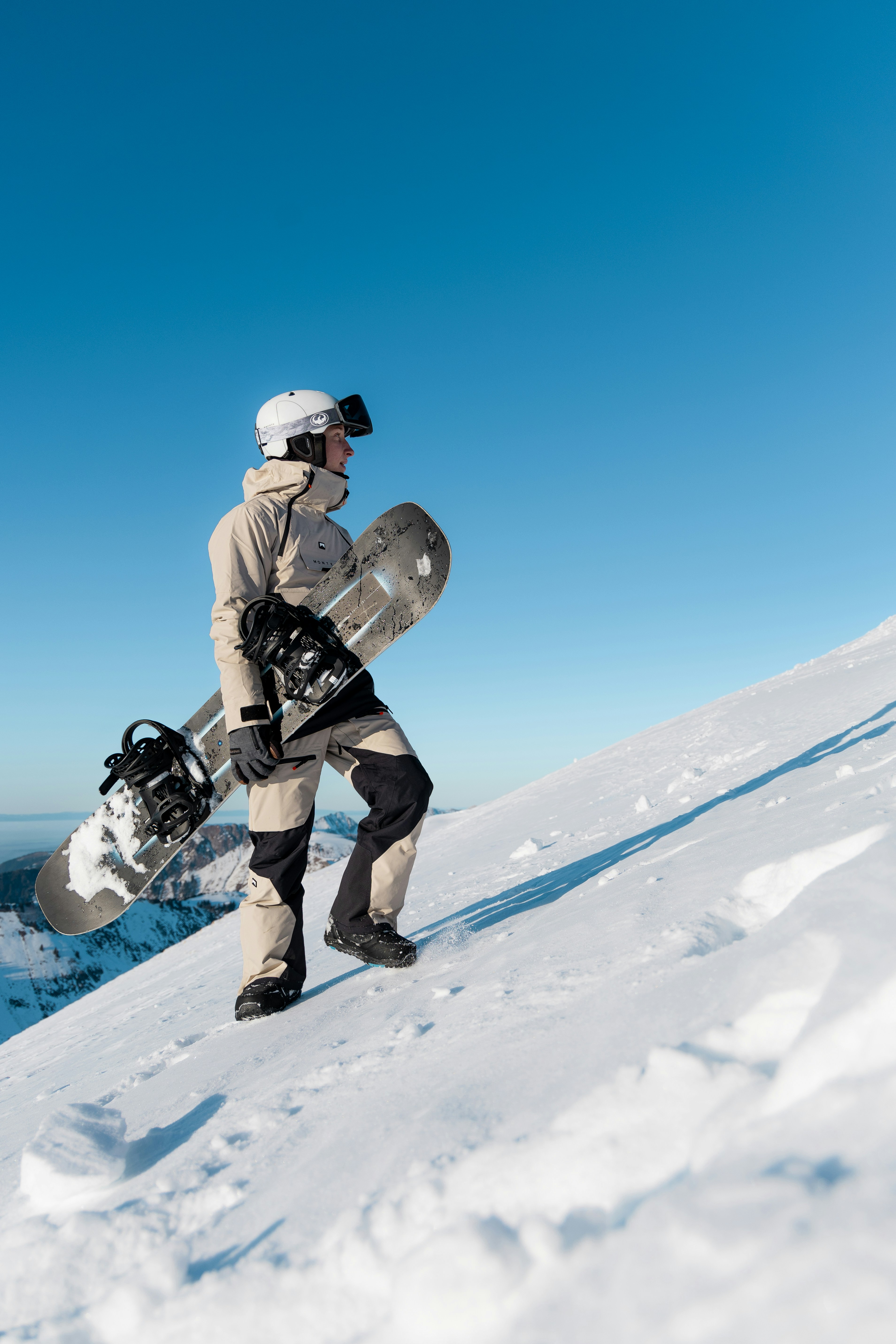 Snowboarder walking uphill on a snowy mountain