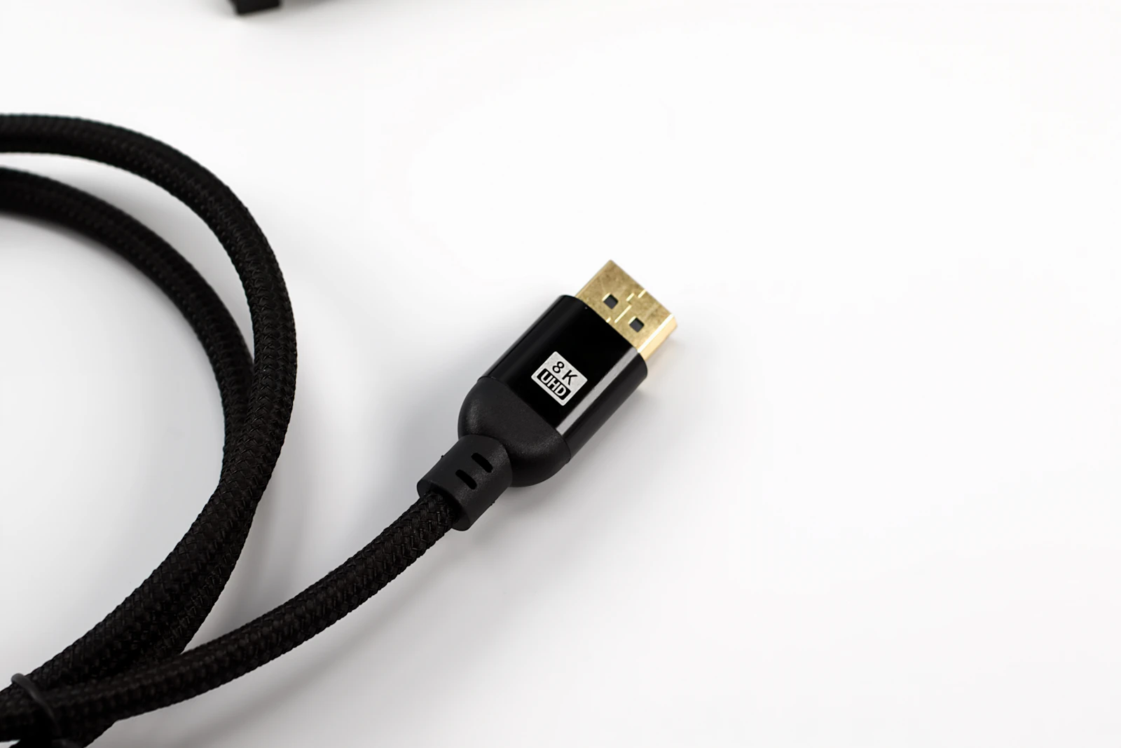 Gold-plated HDMI connector on a black braided cable labeled 8K UHD against a white background