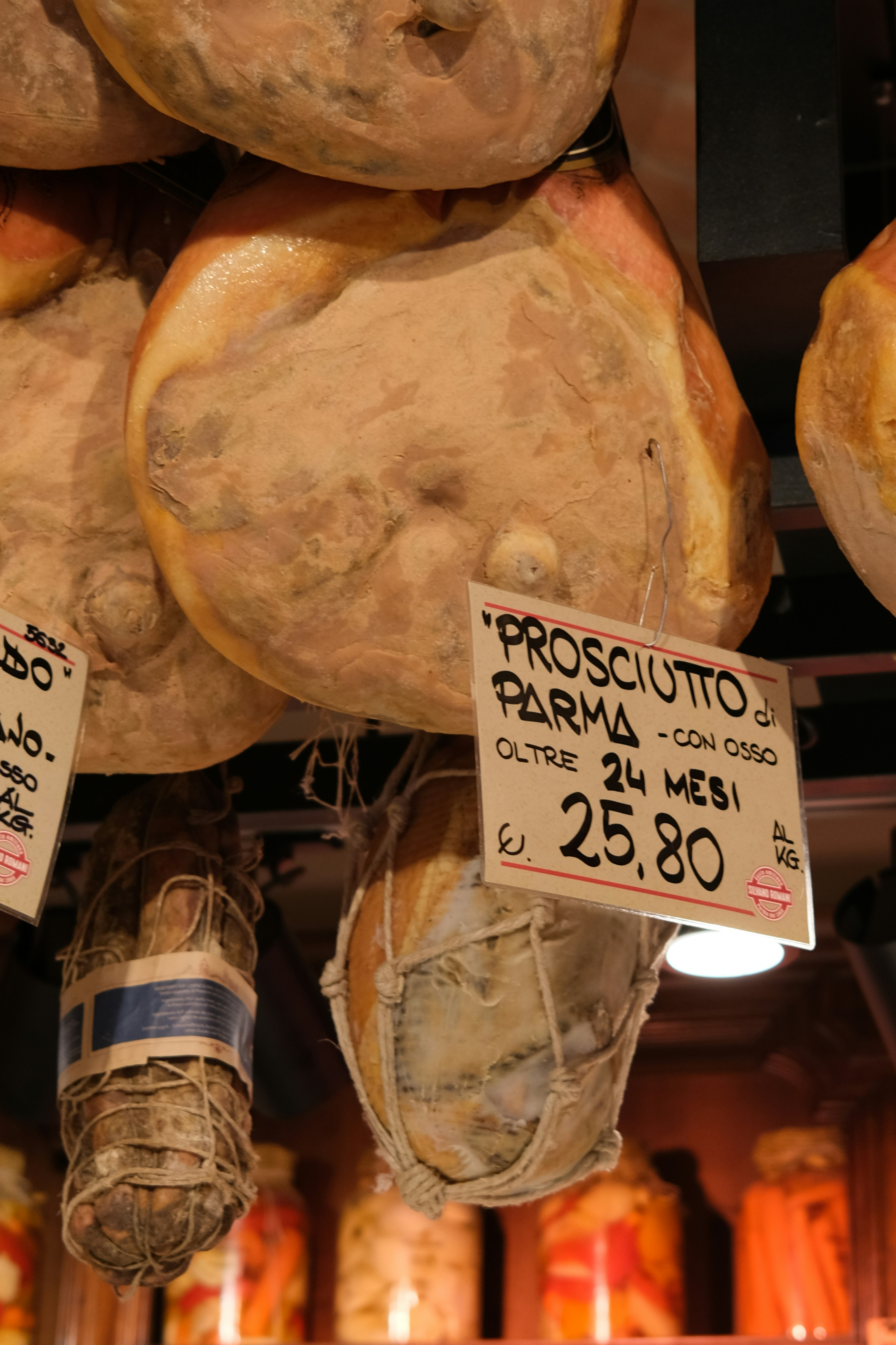 Prosciutto di parma appeso al mercato con cartellino del prezzo