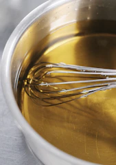 Whisk in a pot of golden liquid
