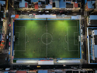 Aerial view of a brightly lit soccer field at night.