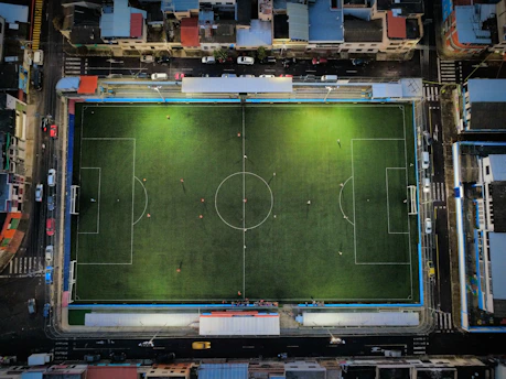 Aerial view of a brightly lit soccer field at night.