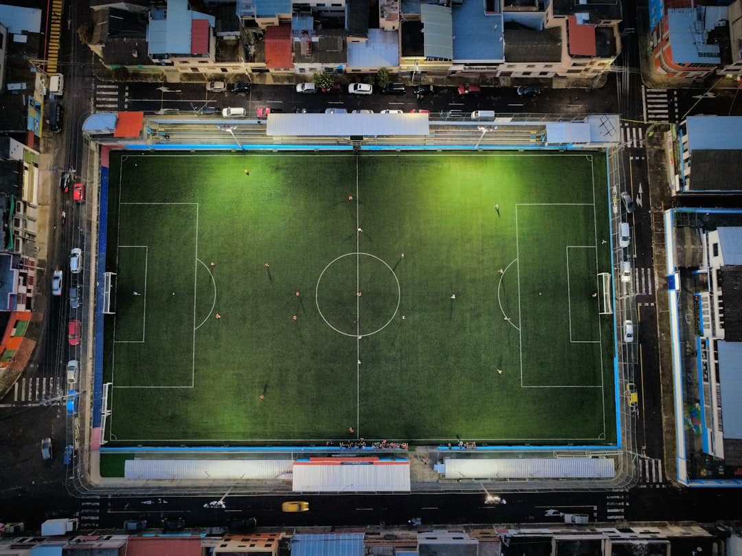 Aerial view of a brightly lit soccer field at night.