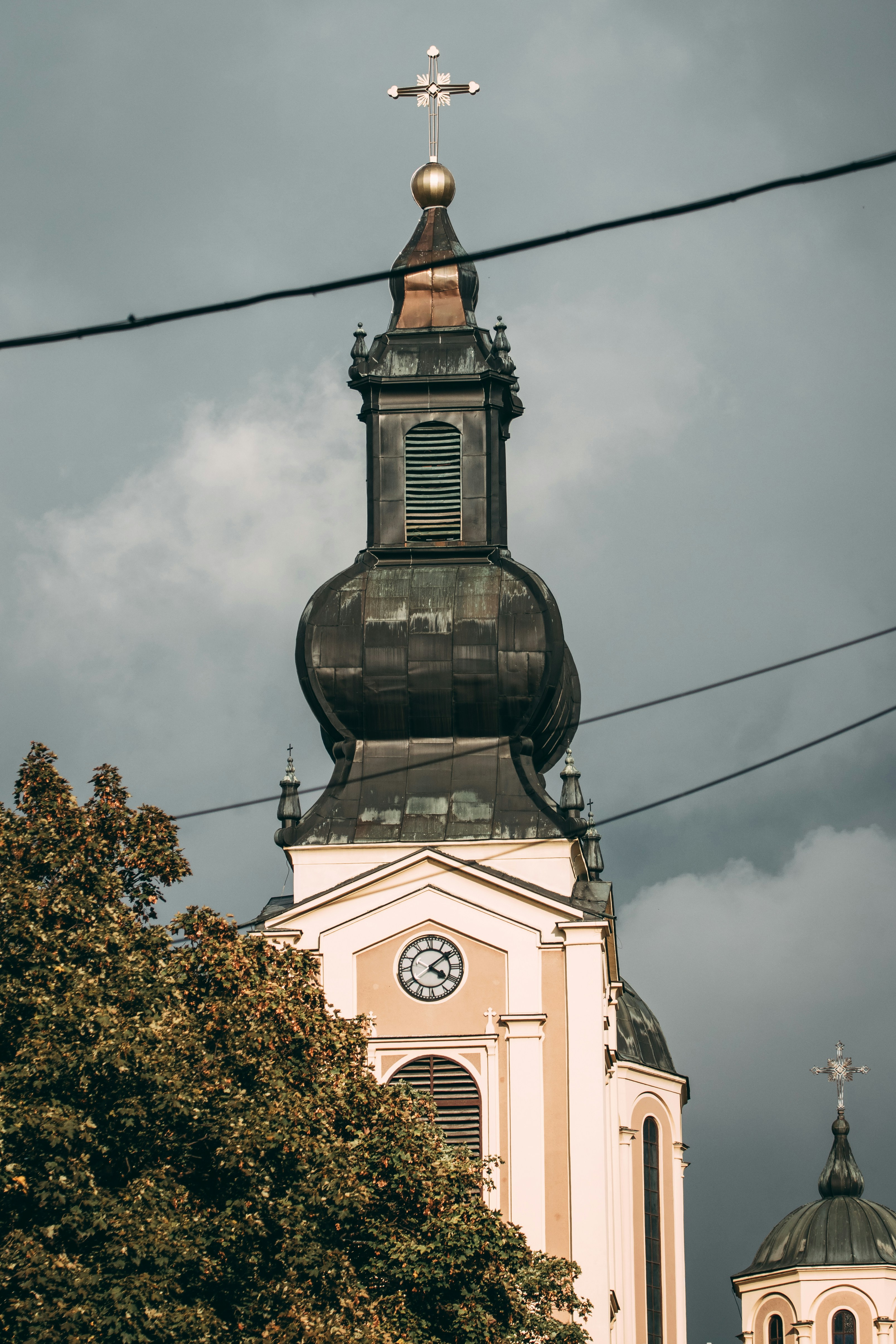 Church tower with a clock under stormy skies
