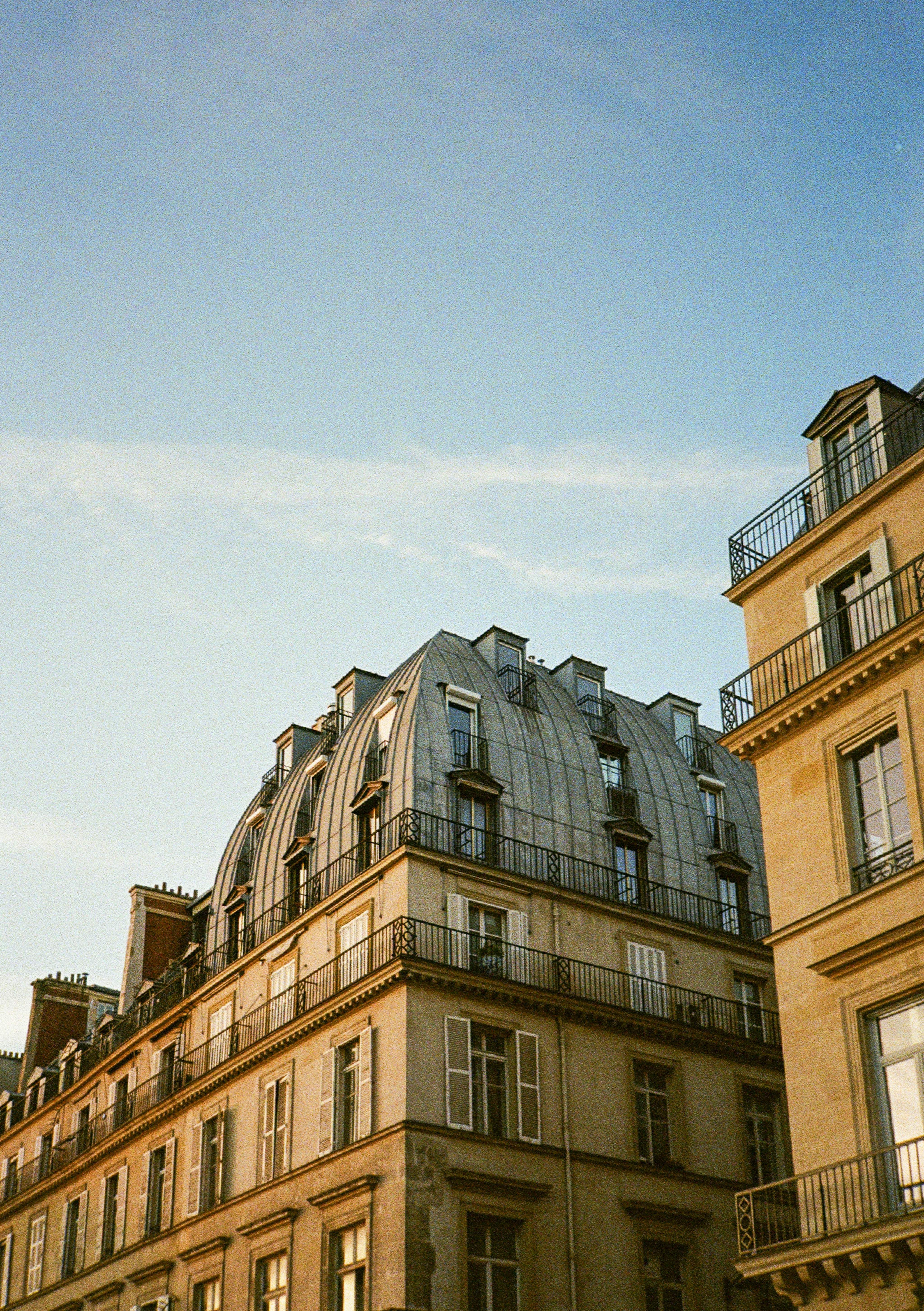 Parisian buildings with mansard roofs under blue sky