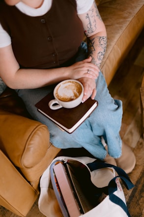 Woman holding a latte with latte art on a book