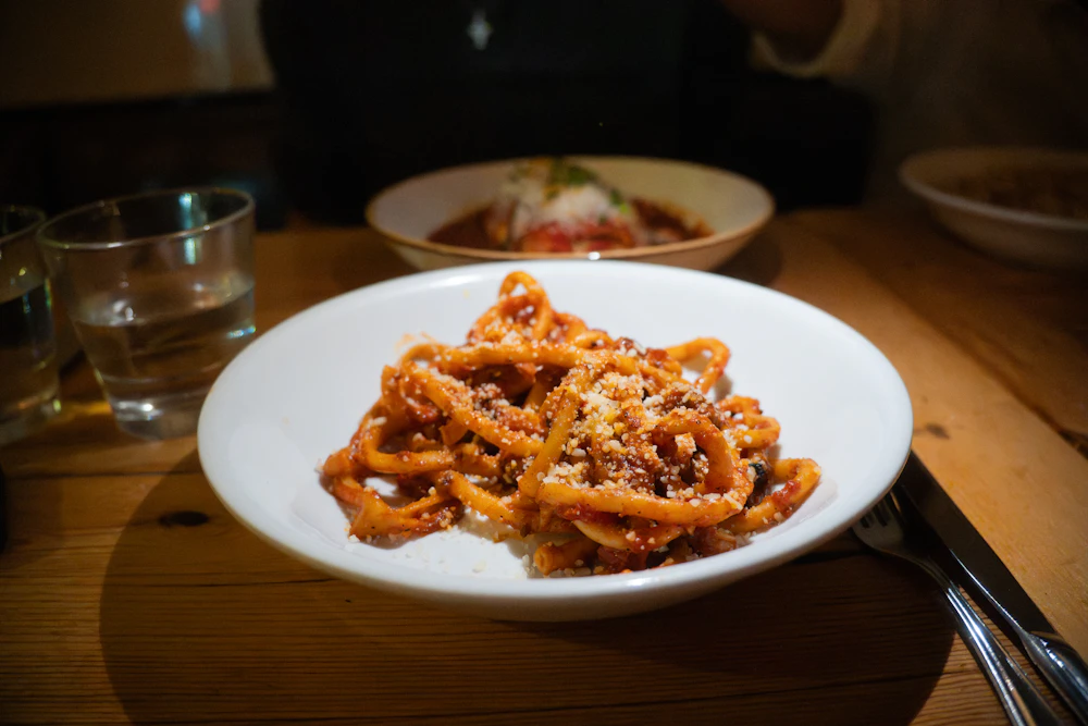 Pasta all'amatriciana in salsa di pomodoro con guanciale rosolato e pecorino grattugiato
