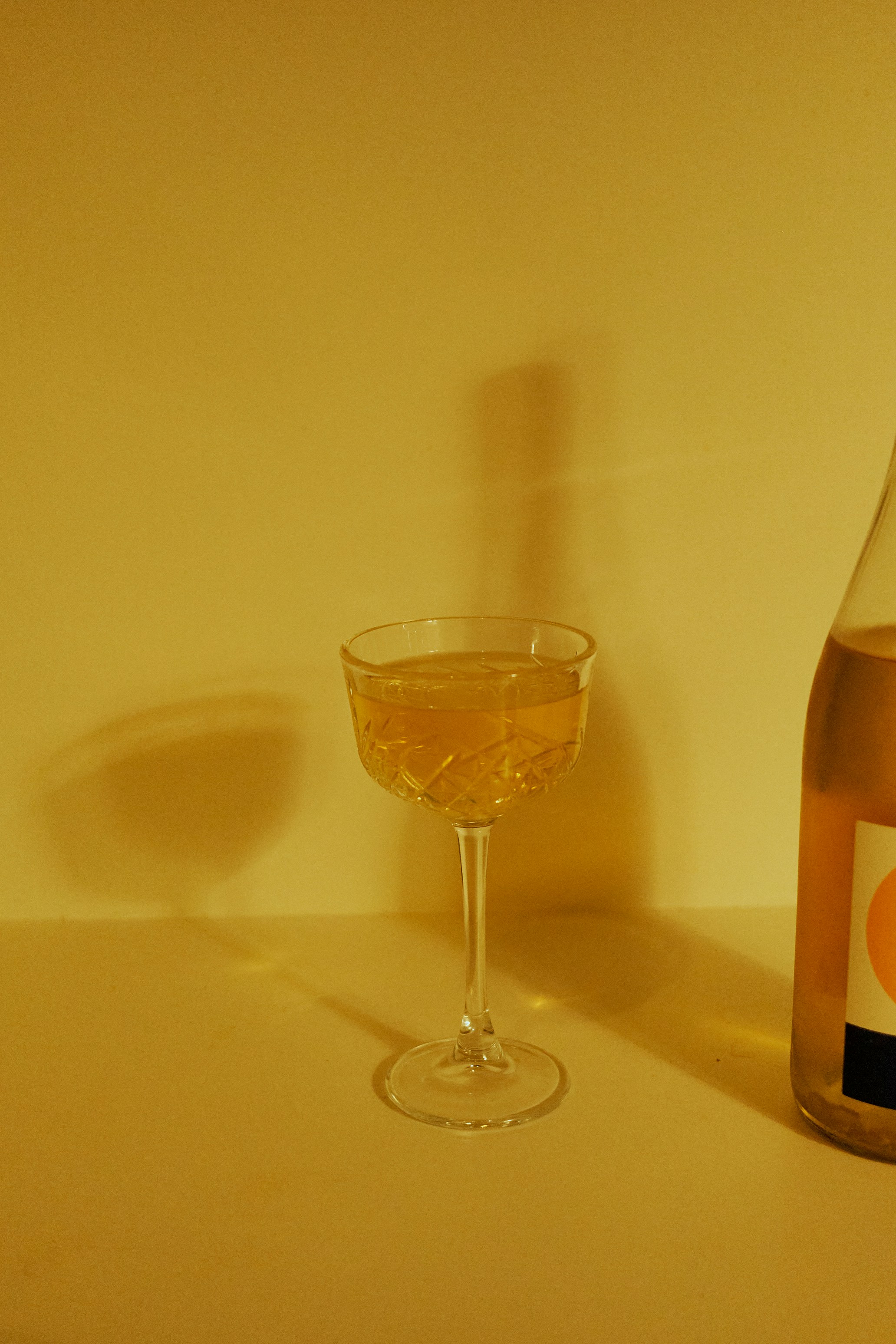 A glass of champagne next to a bottle