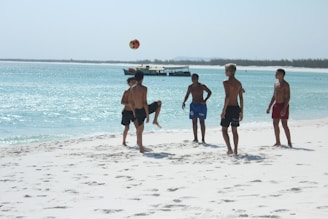 Boys playing soccer on a sunny beach