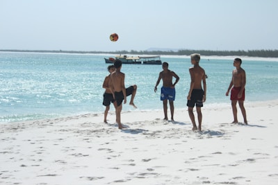 Boys playing soccer on a sunny beach