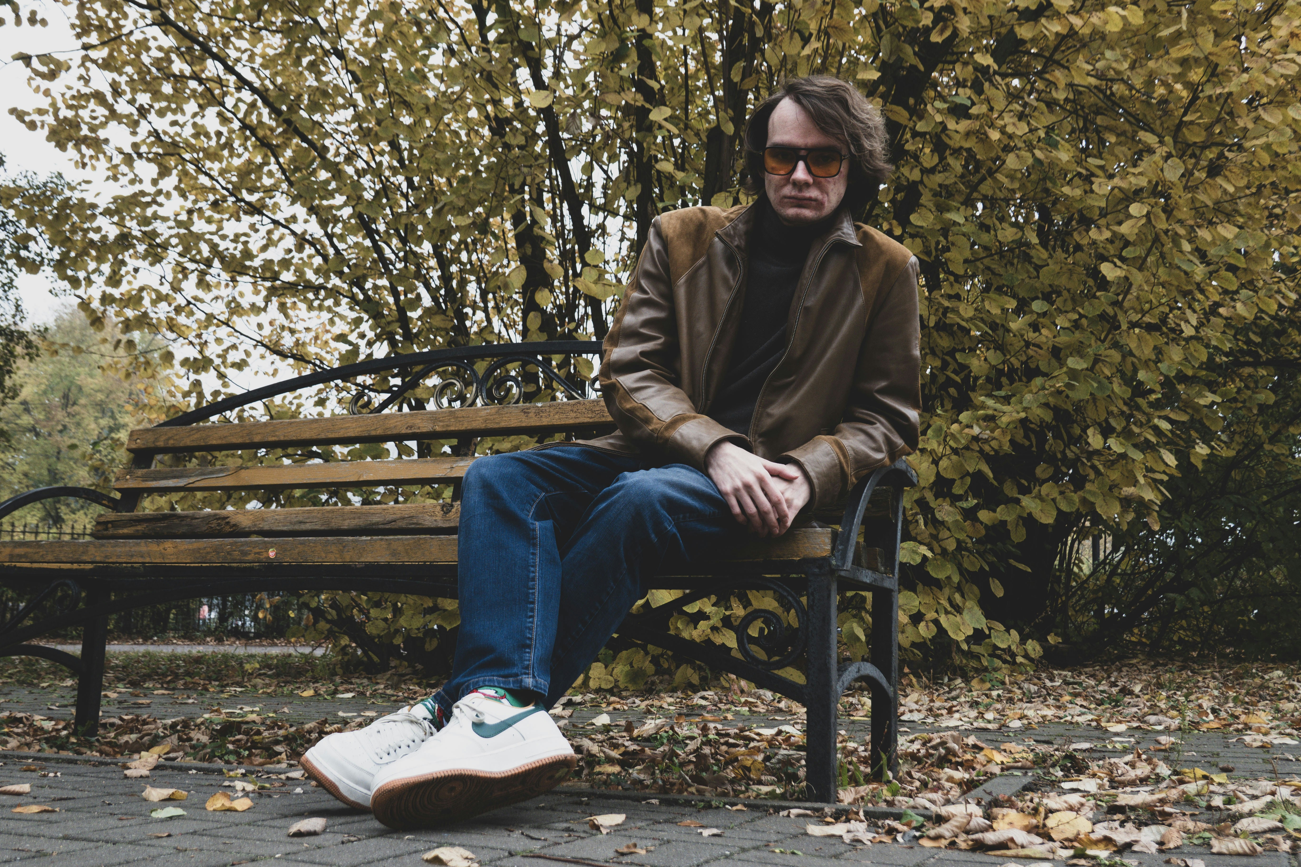 Man sitting on a park bench in autumn.