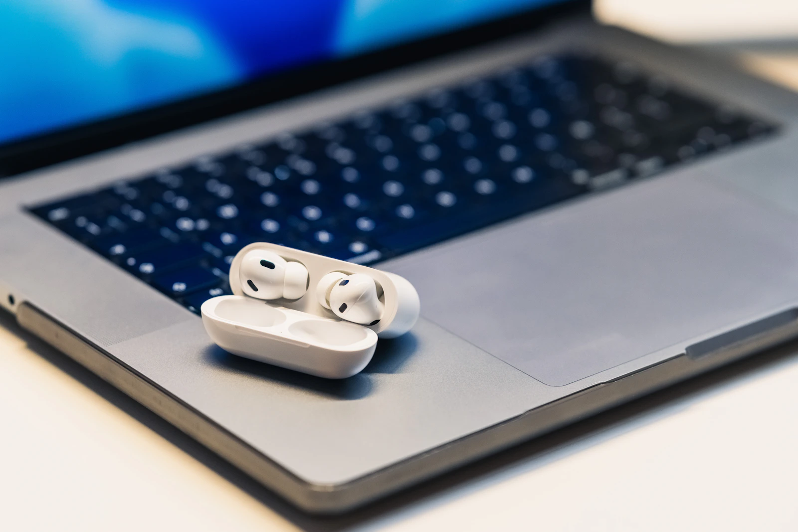 Wireless earbuds resting on a laptop keyboard