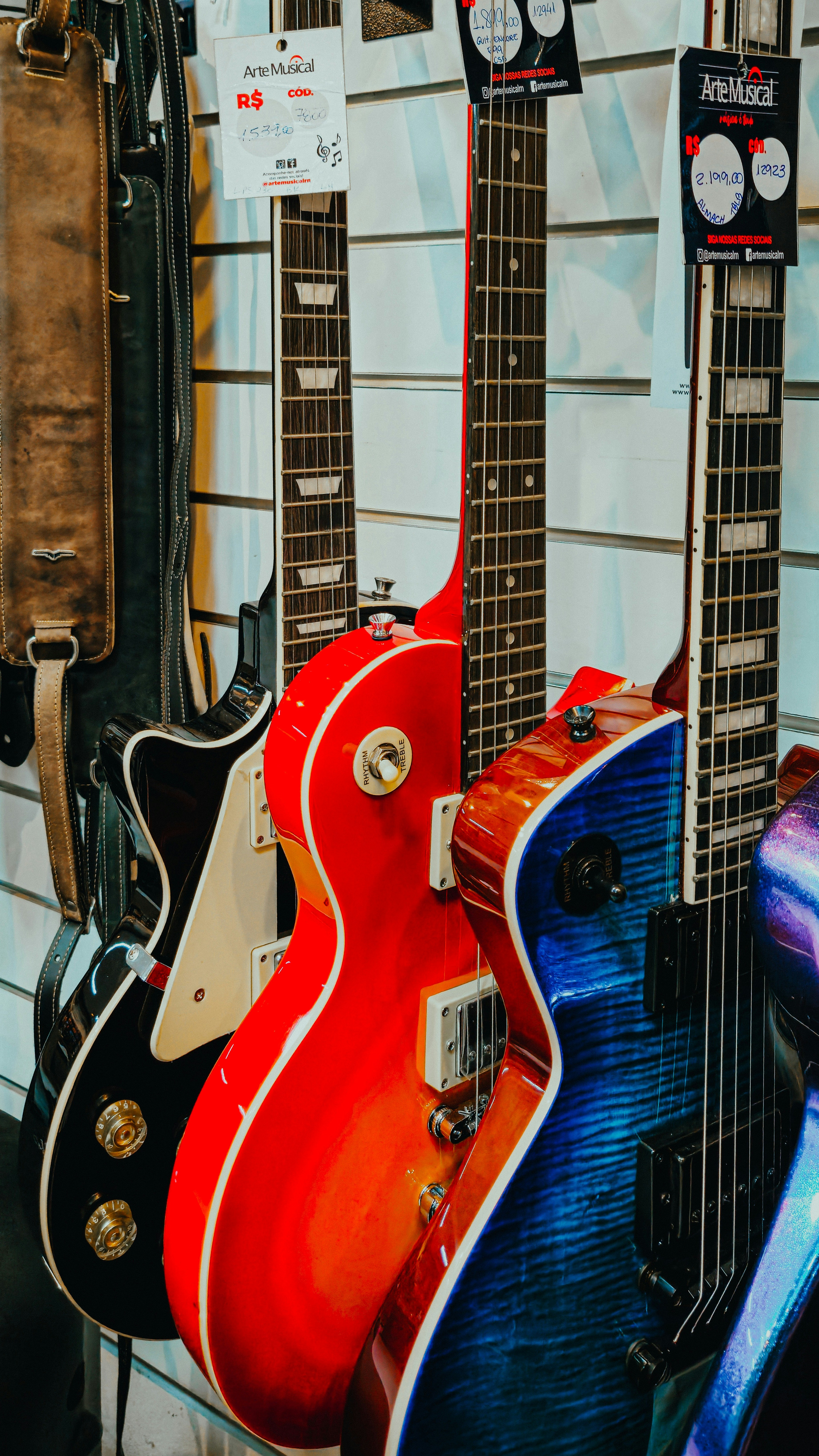 Electric guitars in various vibrant colors hanging