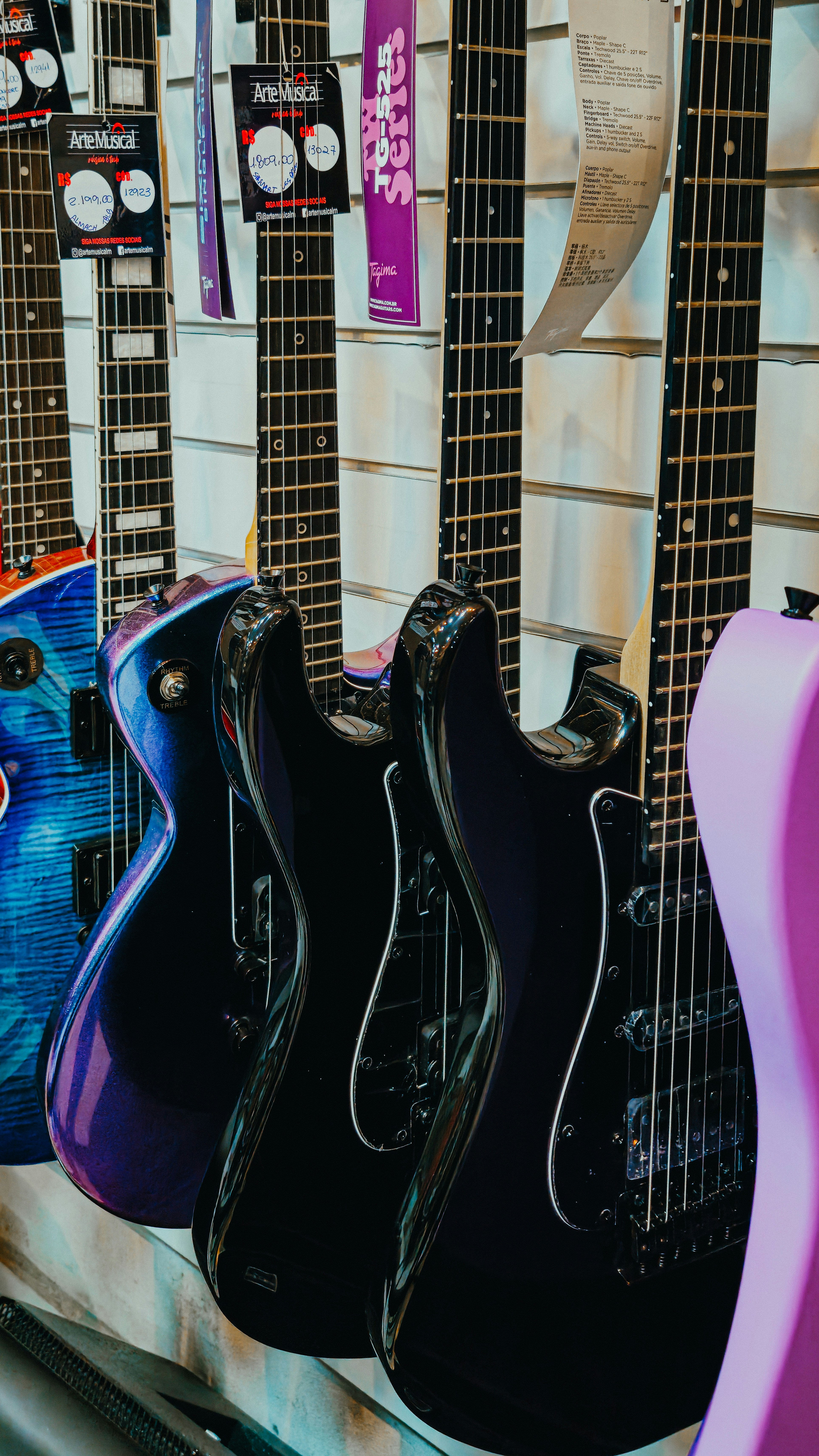Mehrere E-Gitarren hängen an einer Wand.