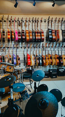 Guitars and drums displayed in a music store.