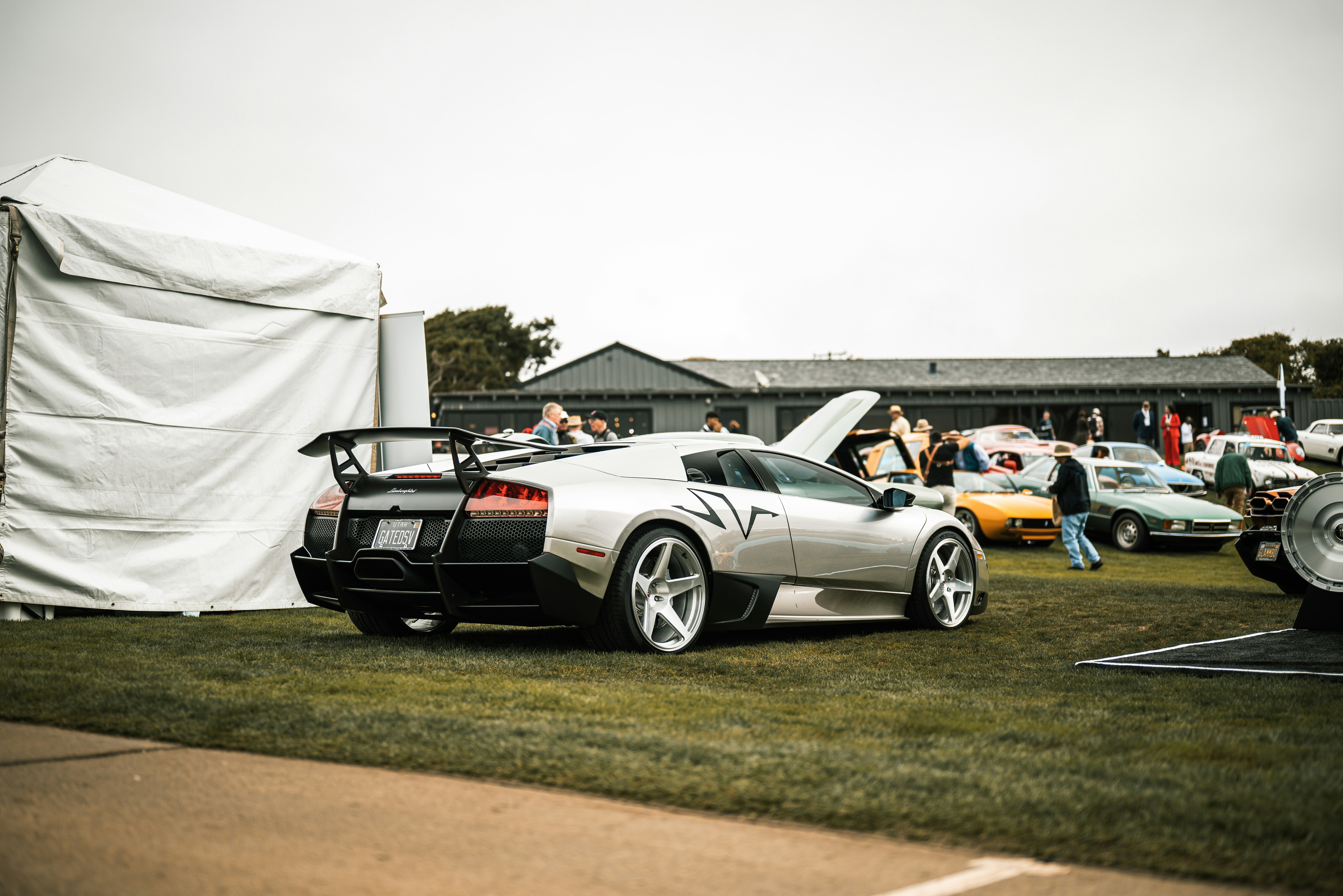 Silver sports car on display at an outdoor event.