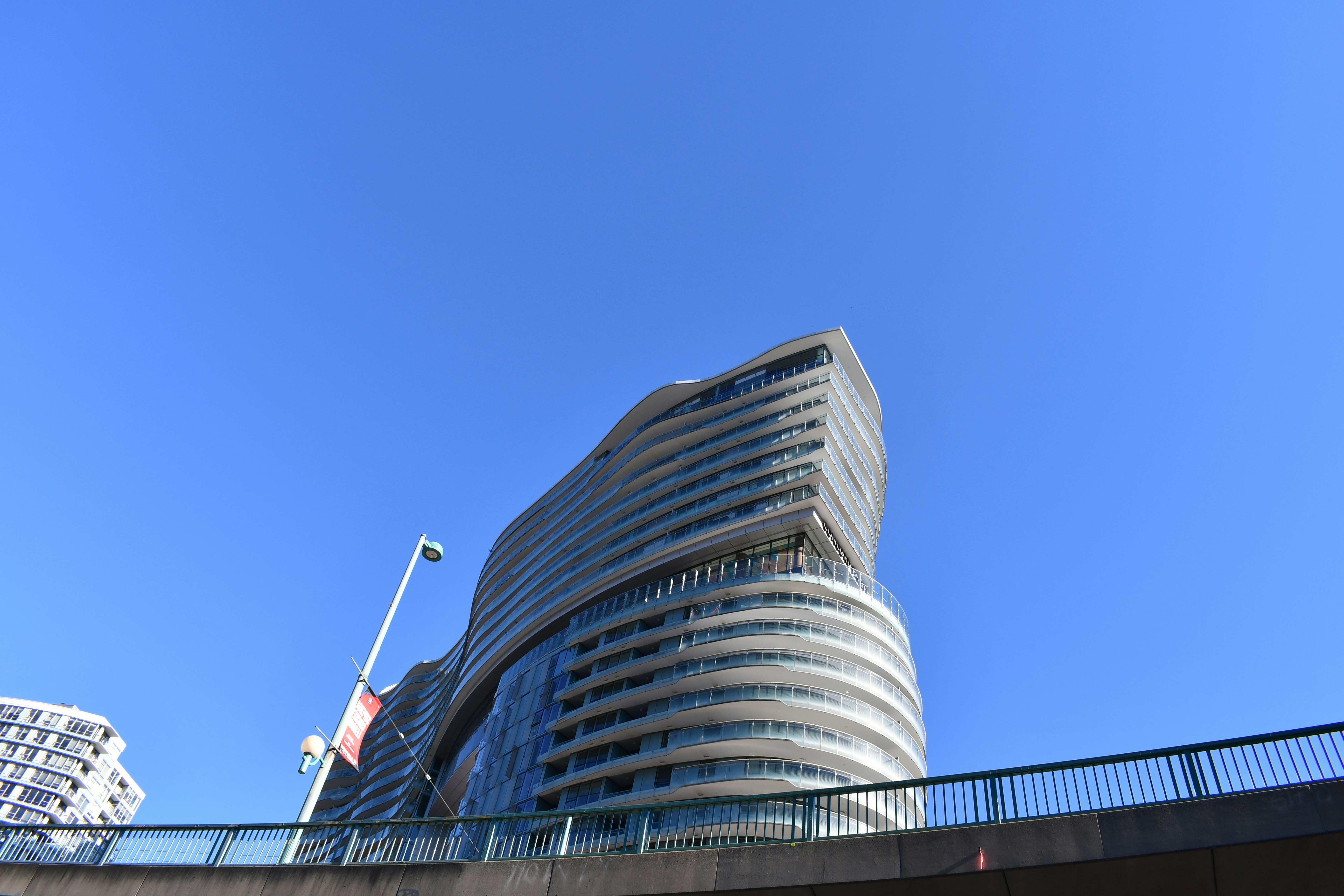 Modernes, geschwungenes Gebäude vor strahlend blauem Himmel