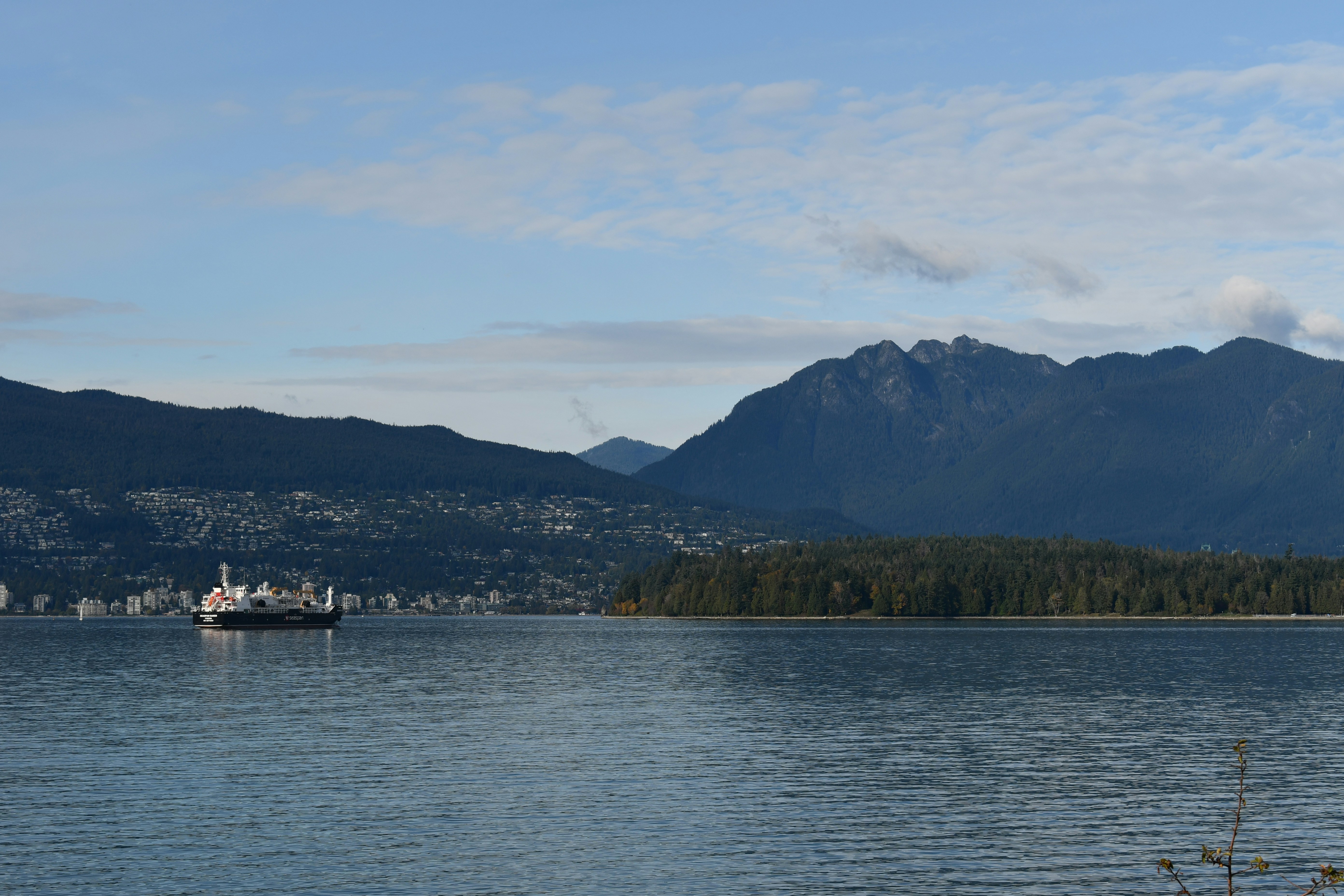 Fähre auf dem Wasser mit Bergen im Hintergrund