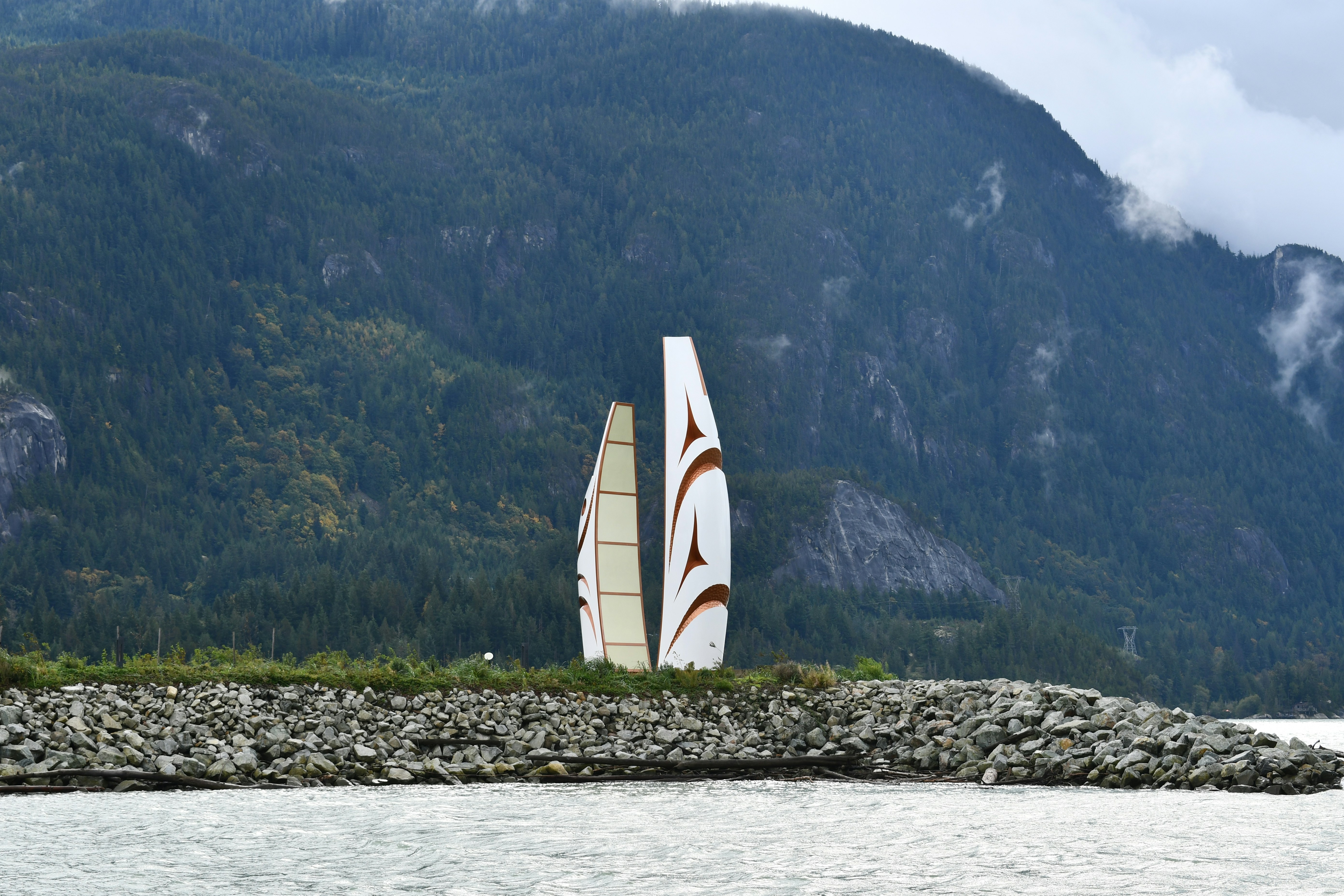 Zwei abstrakte Skulpturen an einem felsigen Ufer