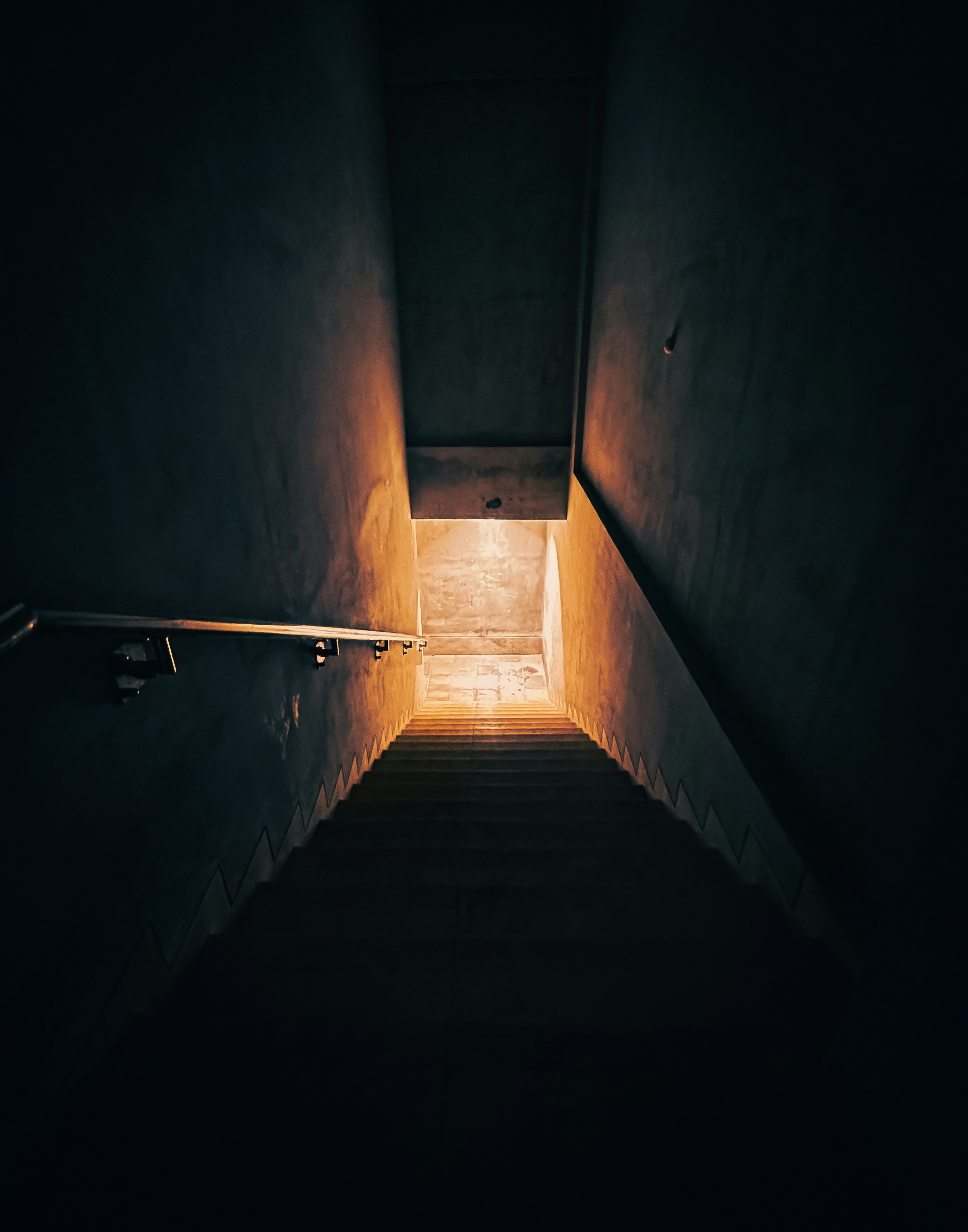 Dunkle Treppe mit leuchtendem Licht unten