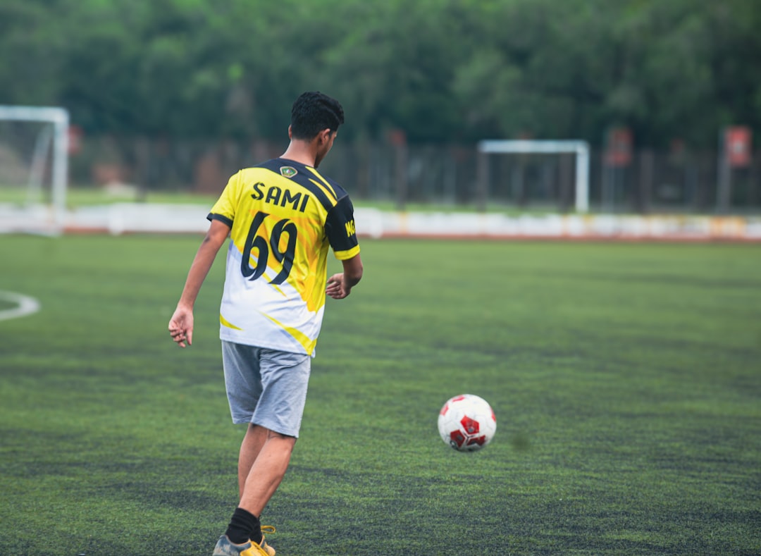 A young man playing soccer on a field.