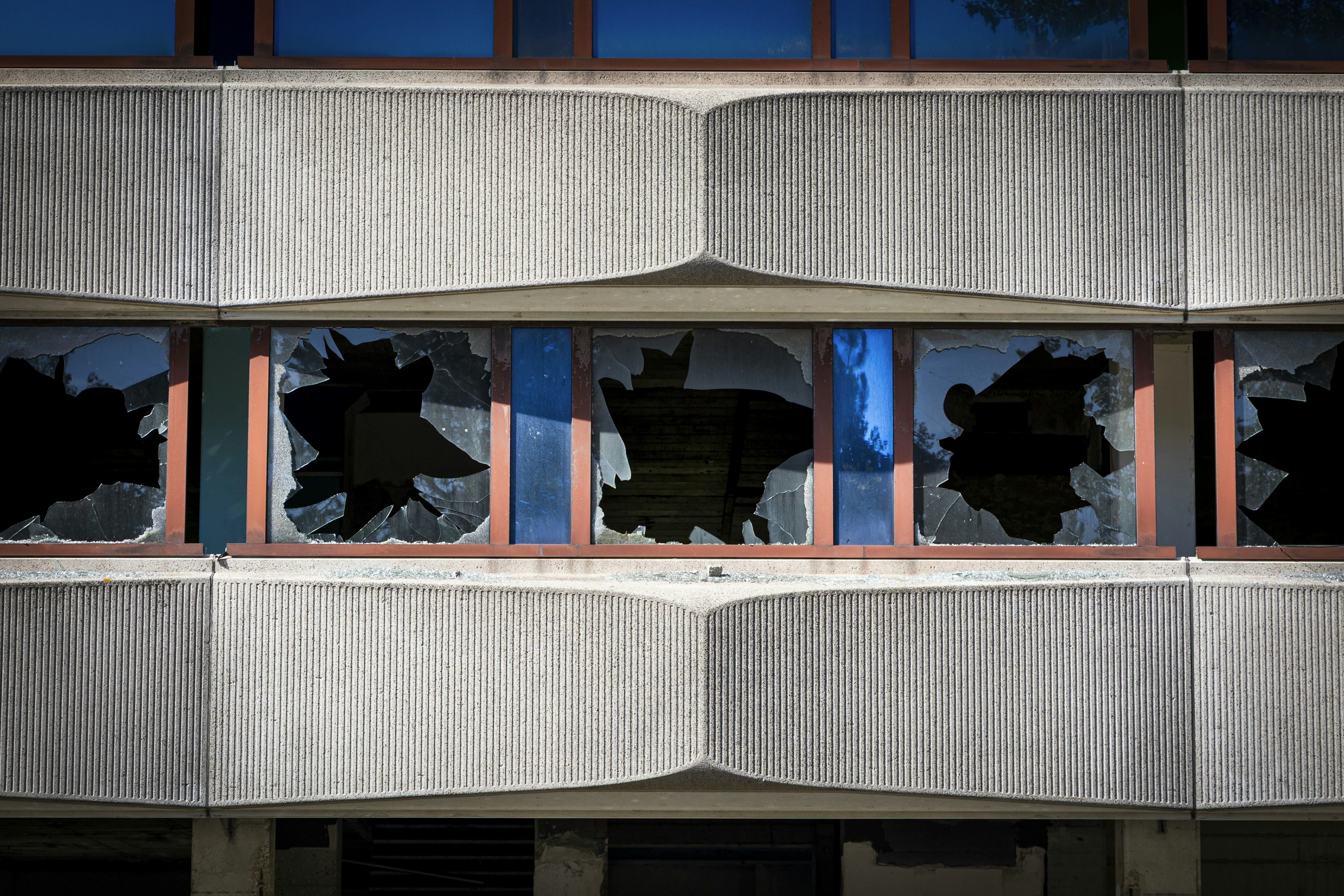 Broken windows on a concrete building facade.