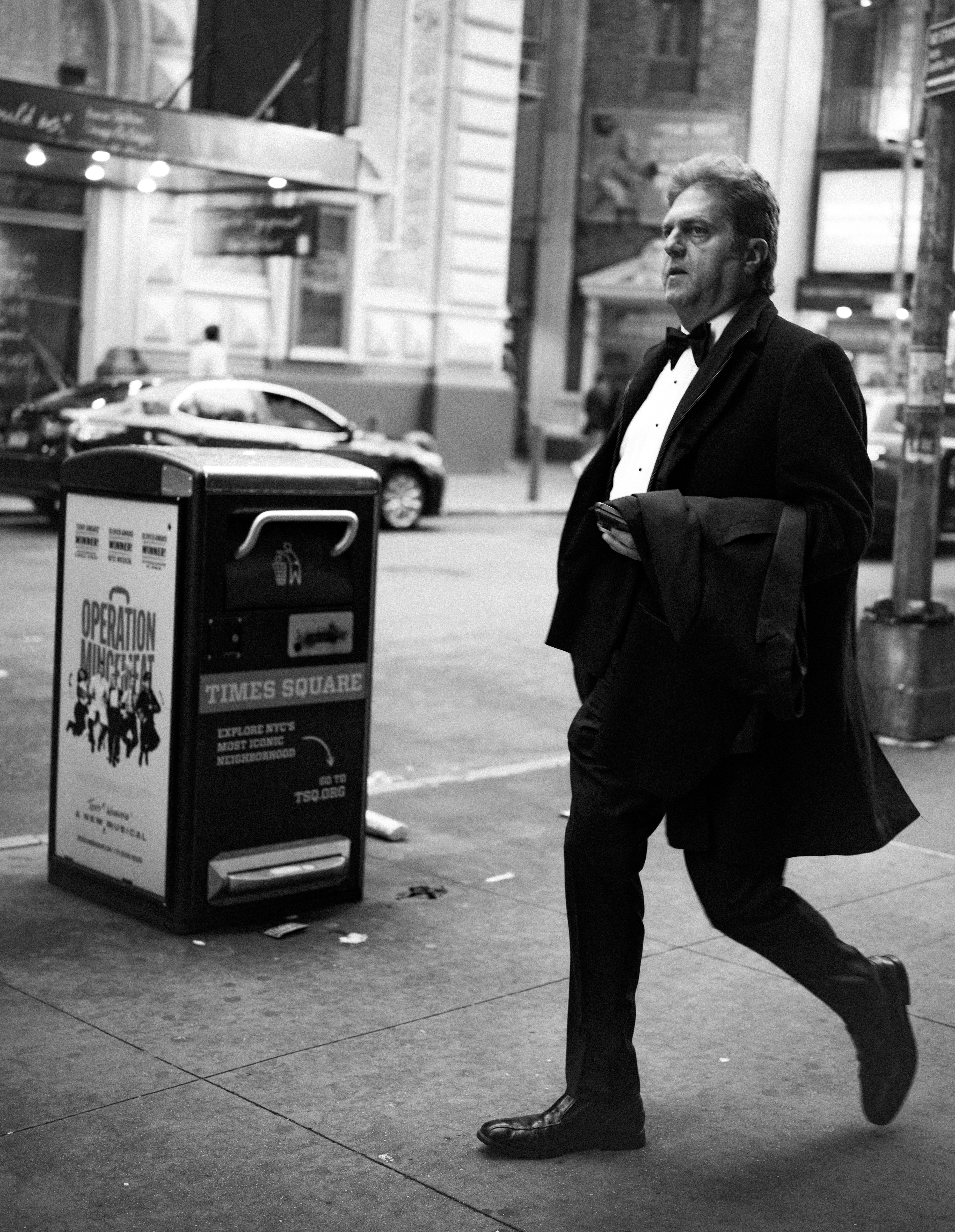 Hombre de esmoquin camina por la calle de la ciudad por la noche