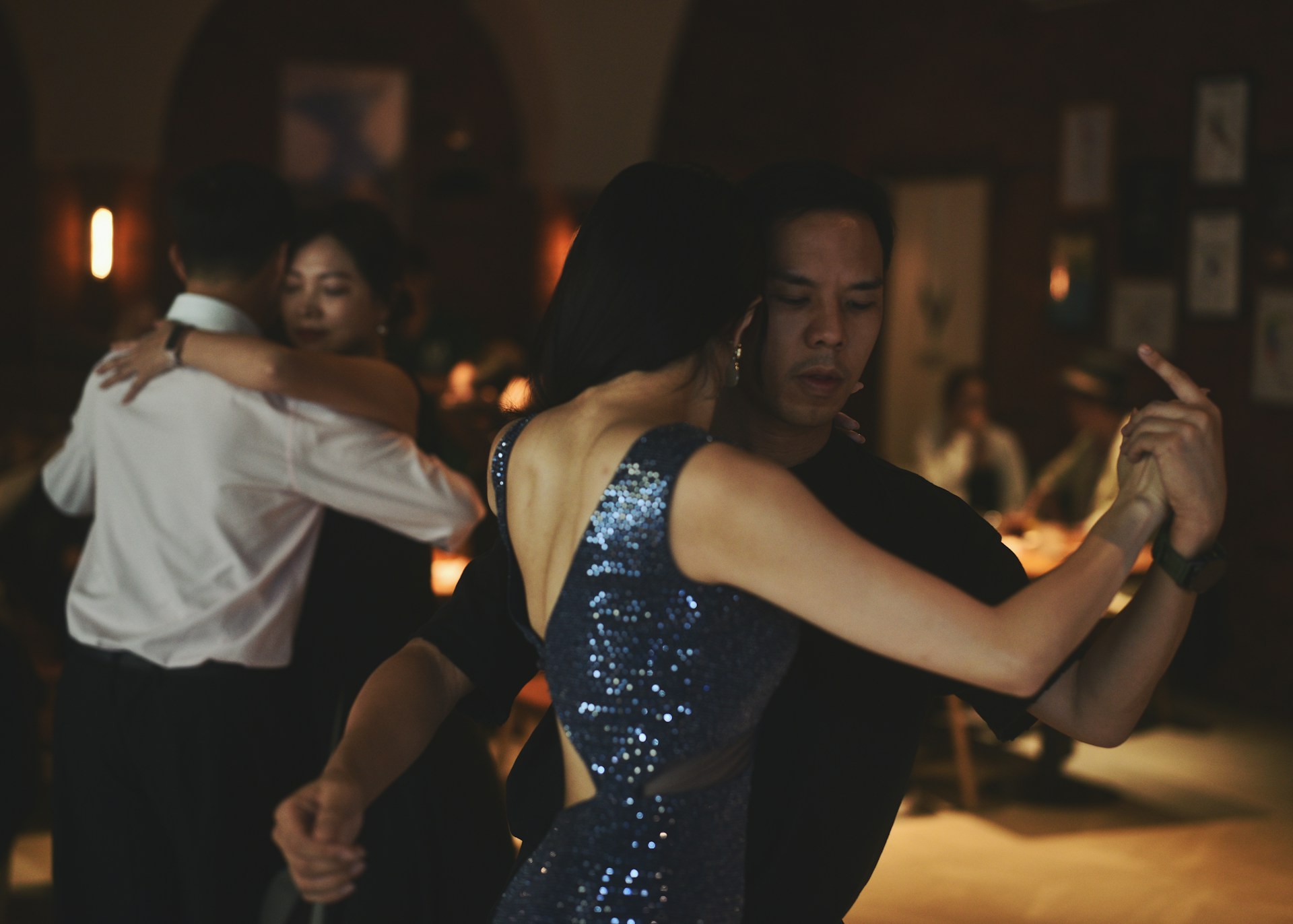 Couples dancing tango in a dimly lit ballroom