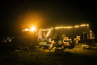 People enjoying a campfire at a campsite at night.