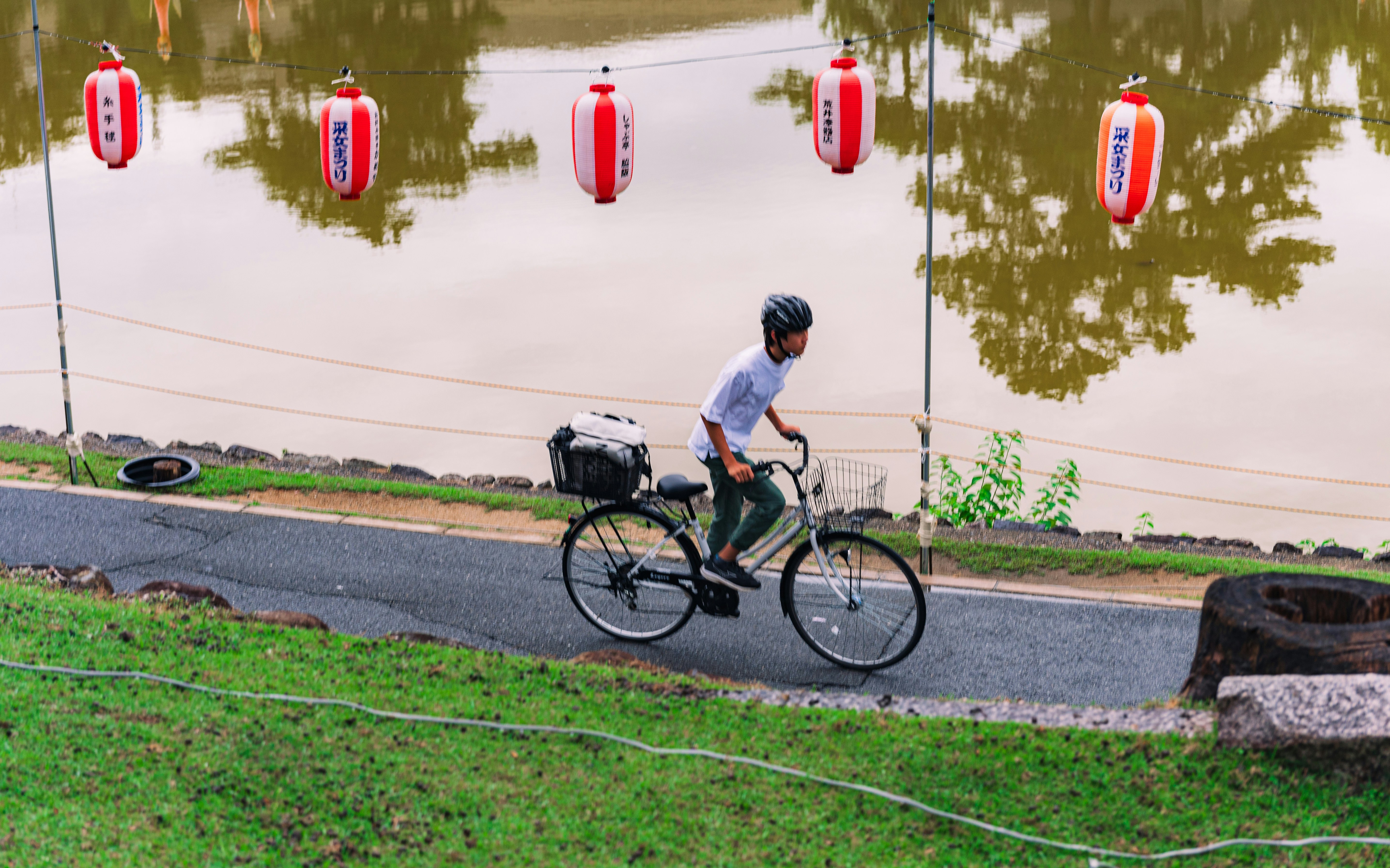 Man riding bicycle along a path near water