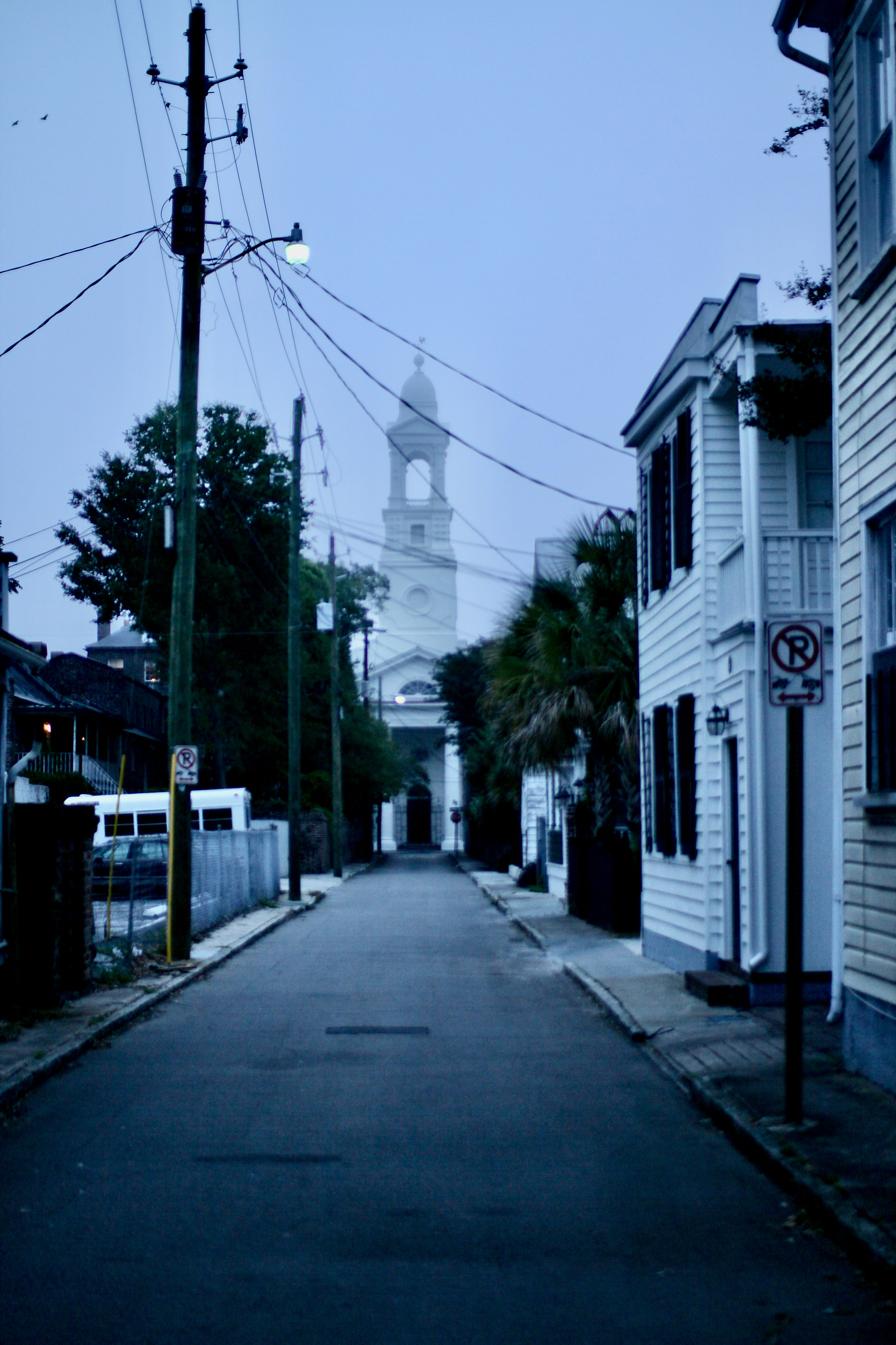 Street leading to a church tower at dusk