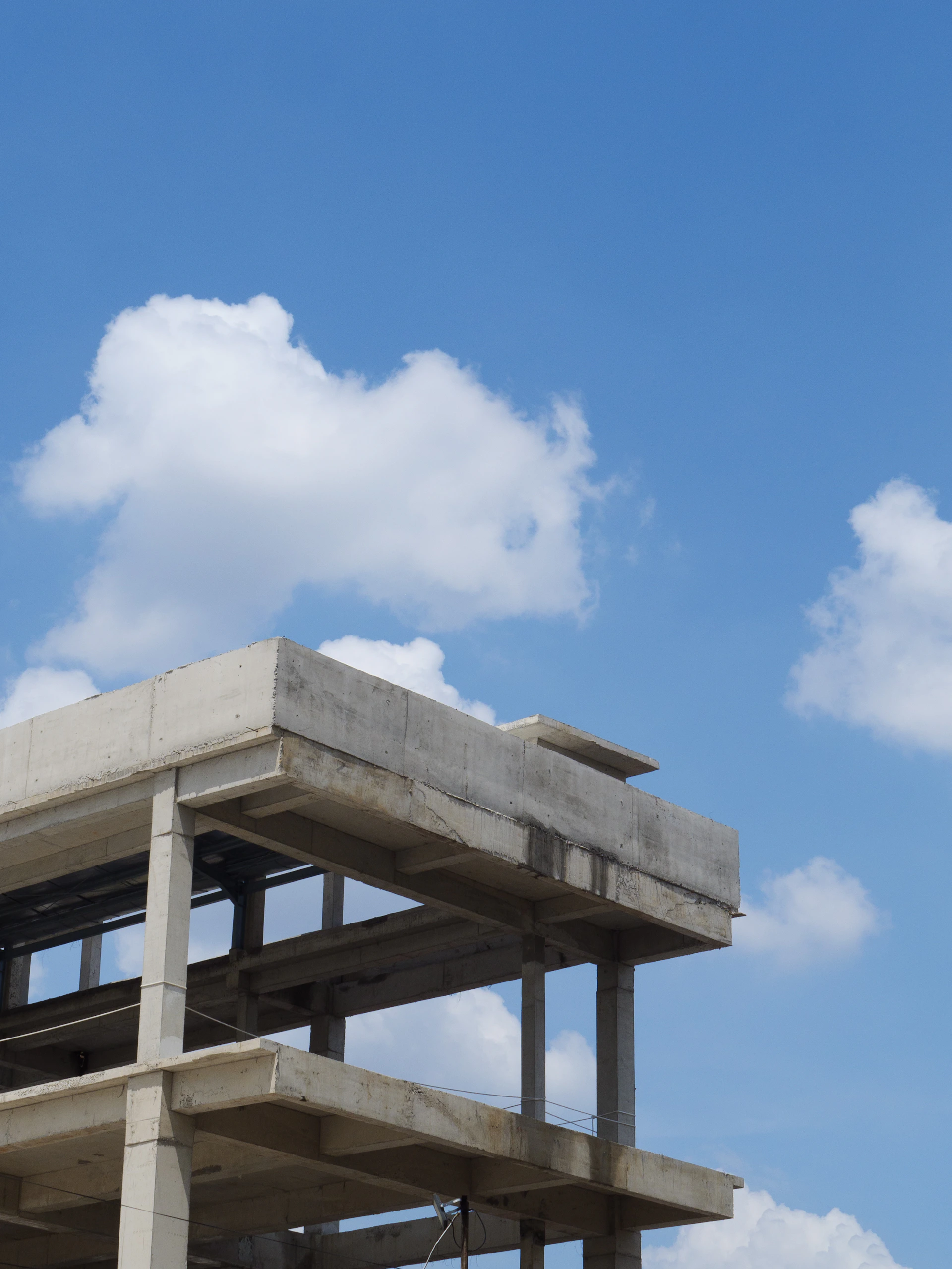 Concrete building under construction against blue sky.